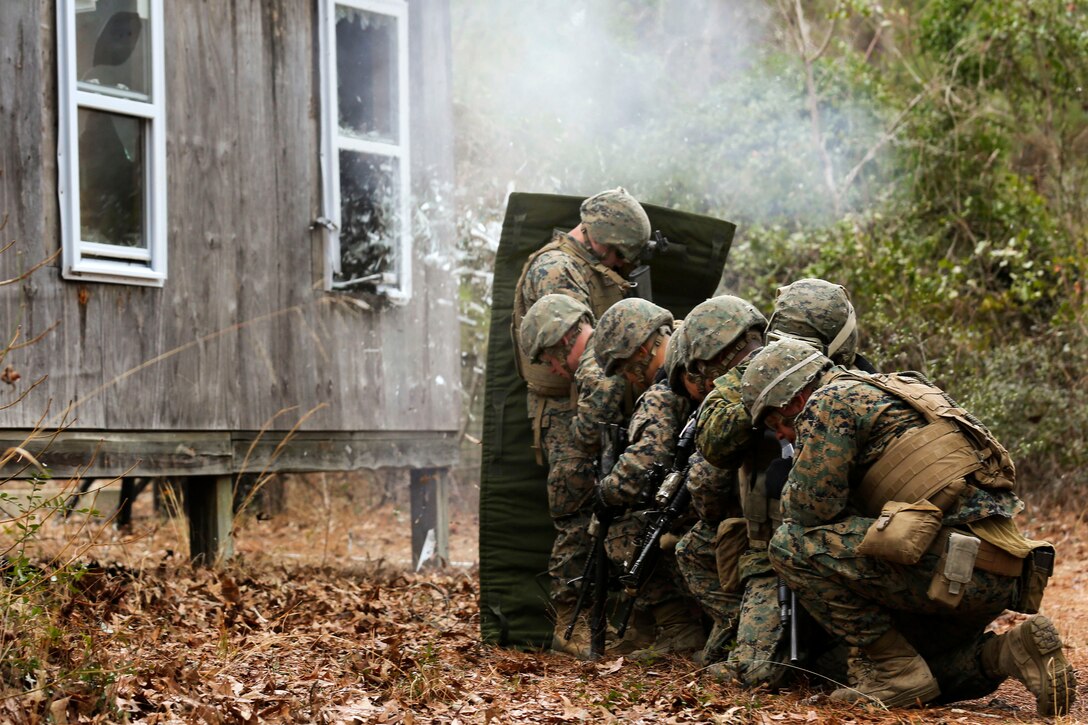 Marines protect themselves behind a blast blanket from shrapnel produced from a detonation cord with blasting caps during an urban breaching course on Camp Lejeune, N.C., March 3, 2015.