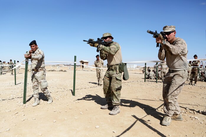 U.S. Marines and coalition forces with Task Force Al Asad teach Iraqi soldiers how to enter rooms using tape houses during Military Operations on Urban Terrain training aboard Al Asad Air Base, Iraq, Feb. 14-16, 2015. The three-day training period utilized different MOUT facilities in order to teach Iraqi soldiers basic room clearing techniques, how to move across linear danger areas as a squad, and the proper way to maneuver through a building in fire teams. (U.S. Marine Corps photo by Cpl. Tony Simmons/RELEASED)