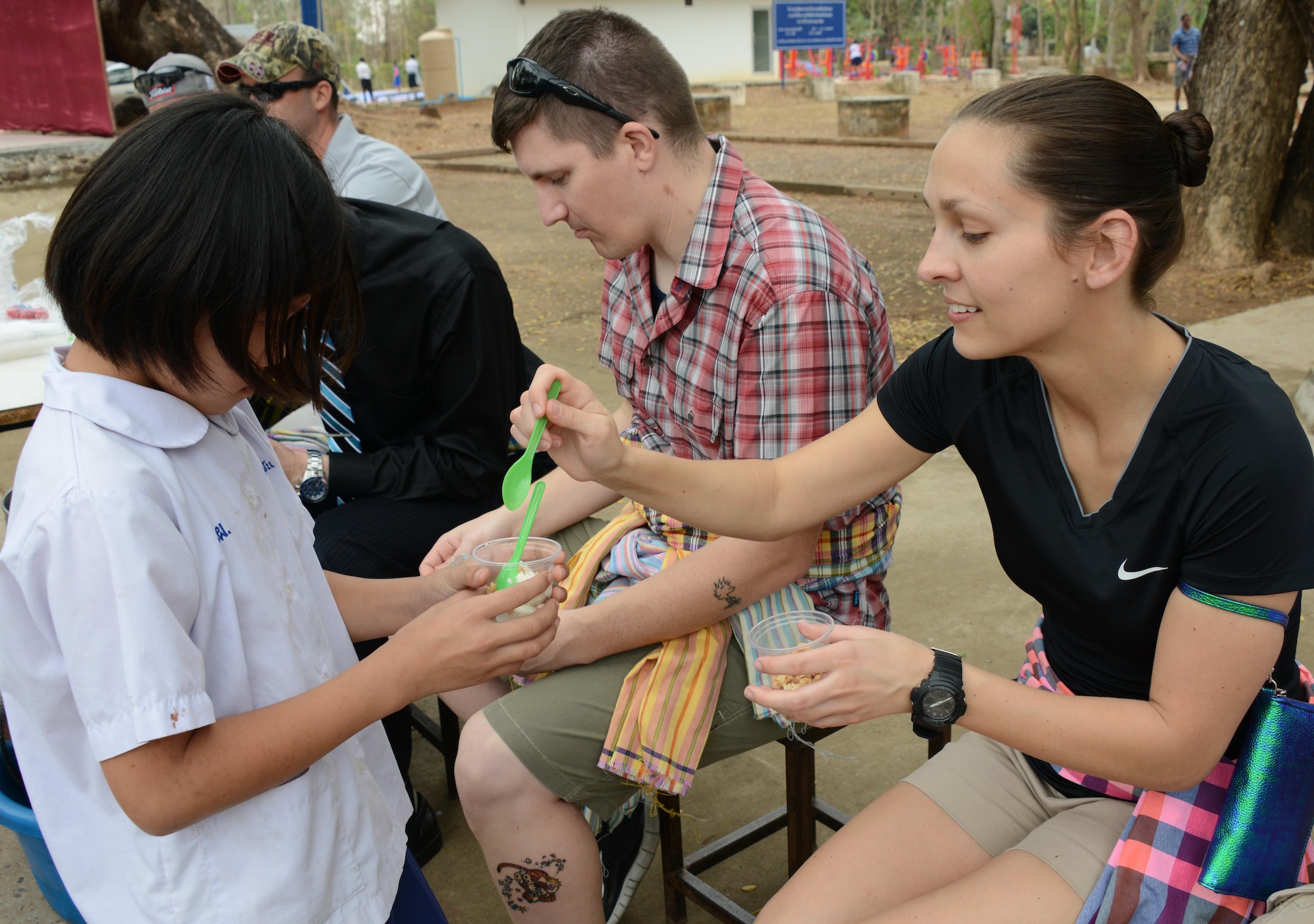 Second Lt. Melissa March, 17th Special Operations Squadron, provides ice cream toppings to a student from Baan Nong Pahi School in Udon Thani, Thailand during a visit to the school Feb. 18, 2015.  Members from the 353rd Special Operations Group raised more than $1,000 and donated sports equipment, ice cream, water coolers along with renovation and medical supplies.  (U.S. Air Force photo by Tech. Sgt. Kristine Dreyer)
