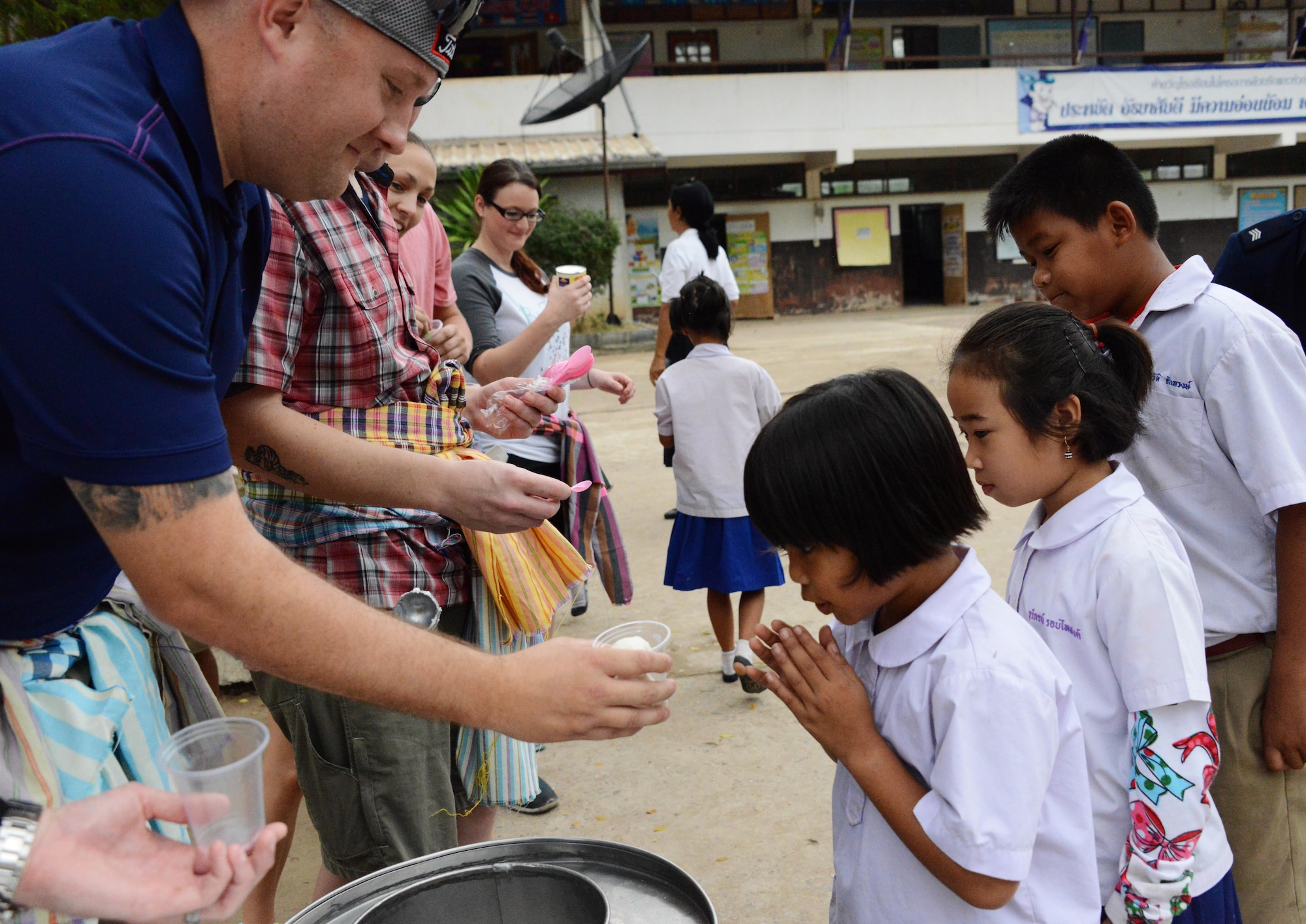 Tech. Sgt. James Williams, 353rd Special Operations Support  Squadron, serves ice cream to children from Baan Nong Pahi School in Udon Thani, Thailand, Feb. 18, 2015.  Members from the 353rd Special Operations Group raised more than $1,000 and donated sports equipment, ice cream, water coolers along with renovation and medical supplies.  (U.S. Air Force photo by Tech. Sgt. Kristine Dreyer)