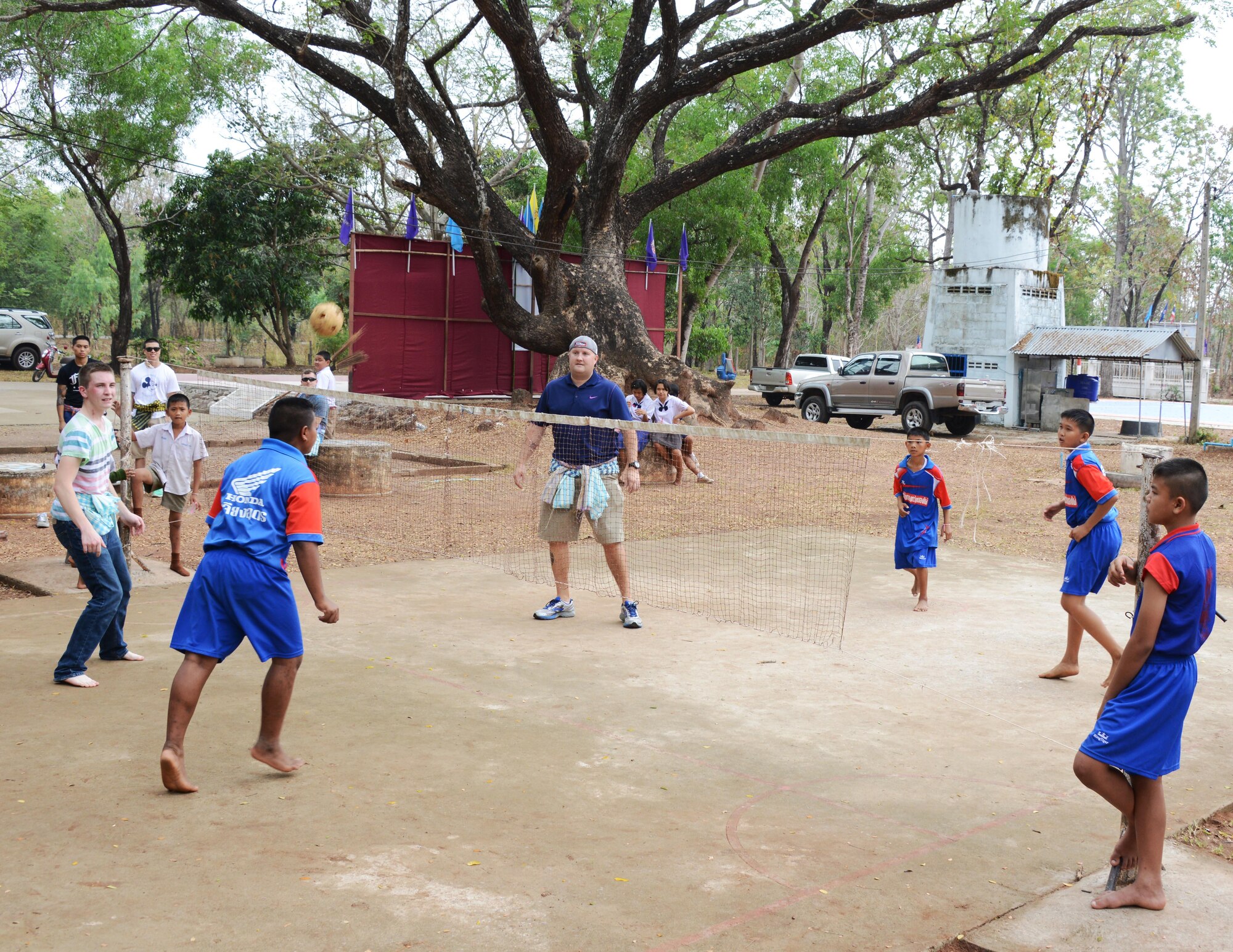 Airmen from the 353rd Special Operations Group and students from Baan Nong Pahi School in Udon Thani, Thailand, play Sepak Takraw or kick volleyball, a sport native to southwest Asia, during a visit to the school Feb. 18, 2015.  Members from the 353rd SOG raised more than $1,000 and donated sports equipment, ice cream, water coolers along with renovation and medical supplies.  (U.S. Air Force photo by Tech. Sgt. Kristine Dreyer)