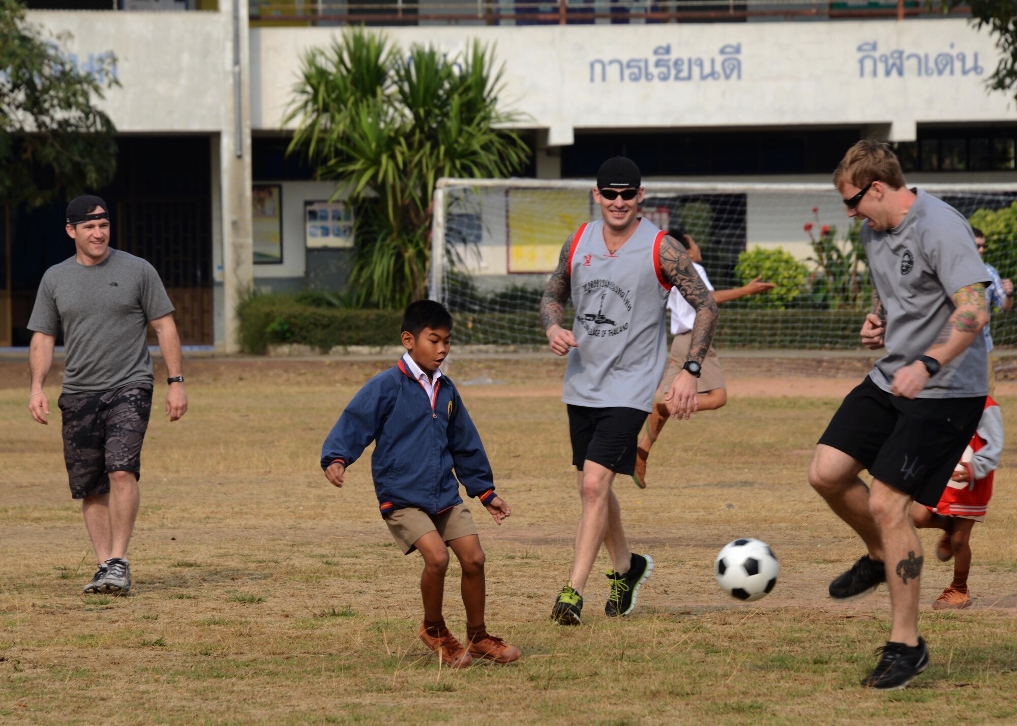 Airmen from the 320th Special Tactics  Squadron play a game of soccer with children from a school in Nam Phong, Thailand, Feb. 17, 2015.  A group from the 320th STS donated sports equipment and spent the morning playing soccer and visiting with the children.  (U.S. Air Force photo by Tech. Sgt. Kristine Dreyer)