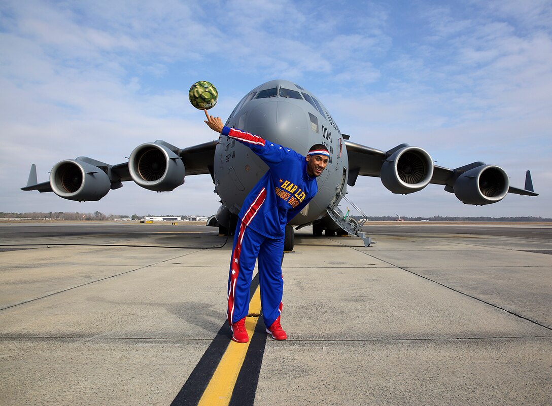 The Globemaster and the Globetrotter. Harlem Globetrotter "Zeus" McClurkin shows his skills in front of a C-17 Globemaster III during a visit to Joint Base Charleston S.C. "Zeus" was here to meet Reservist Tech. Sgt. Jeffrey Landis, 315th Maintenance Squadron. Landis was selected as the Globetrotters' Hometown Hero for their March 10 game in North Charleston. (U.S. Air Force Photo by Tech. Sgt. Shane Ellis)
