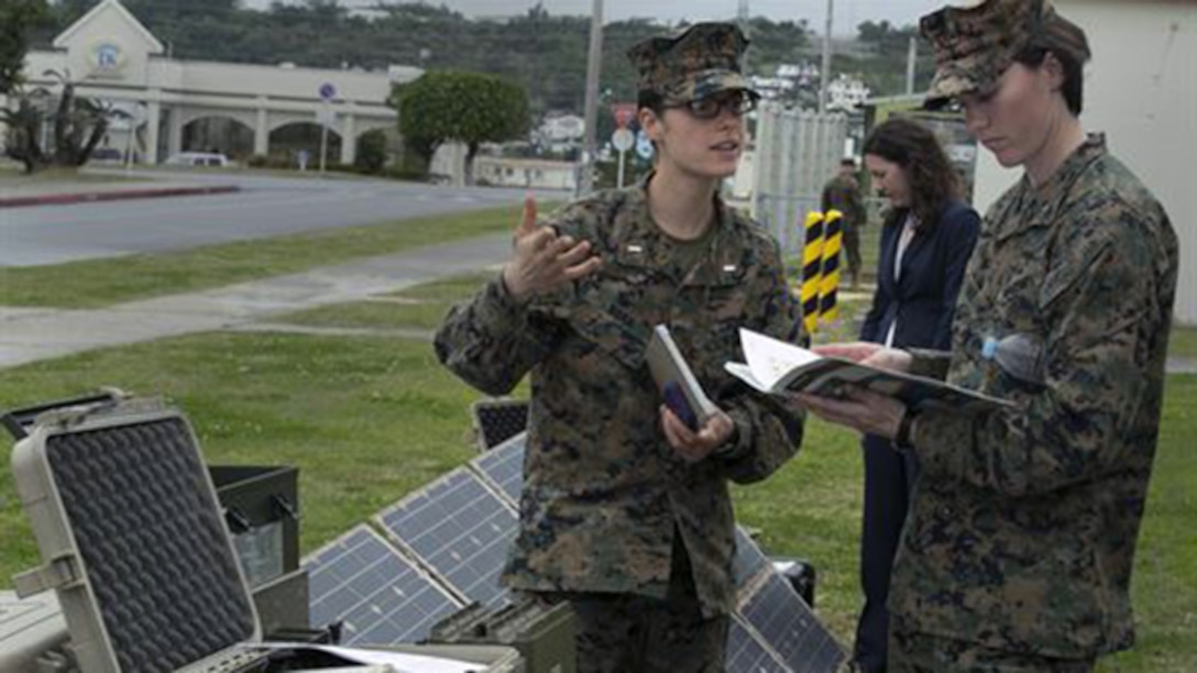 1st Lt. Catherine Nuar, left, and 1st Lt. Rachel Cline, right, have a discussion while observing an energy-efficient advanced power system after an energy efficiency briefing Feb. 26 outside the Camp Foster Theater on Okinawa. The technology provides alternative power options for energizing communications equipment, computers and other electronic equipment in an expeditionary environment. Nuar is a native of Manassas, Virginia, and logistics officer with Marine Aviation Logistics Squadron 36, Marine Aircraft Group 36, 1st Marine Aircraft Wing, III Marine Expeditionary Force. Cline is a native of Denver, Colorado and a logistics officer with Combat Assault Battalion, 3rd Marine Division, III MEF.