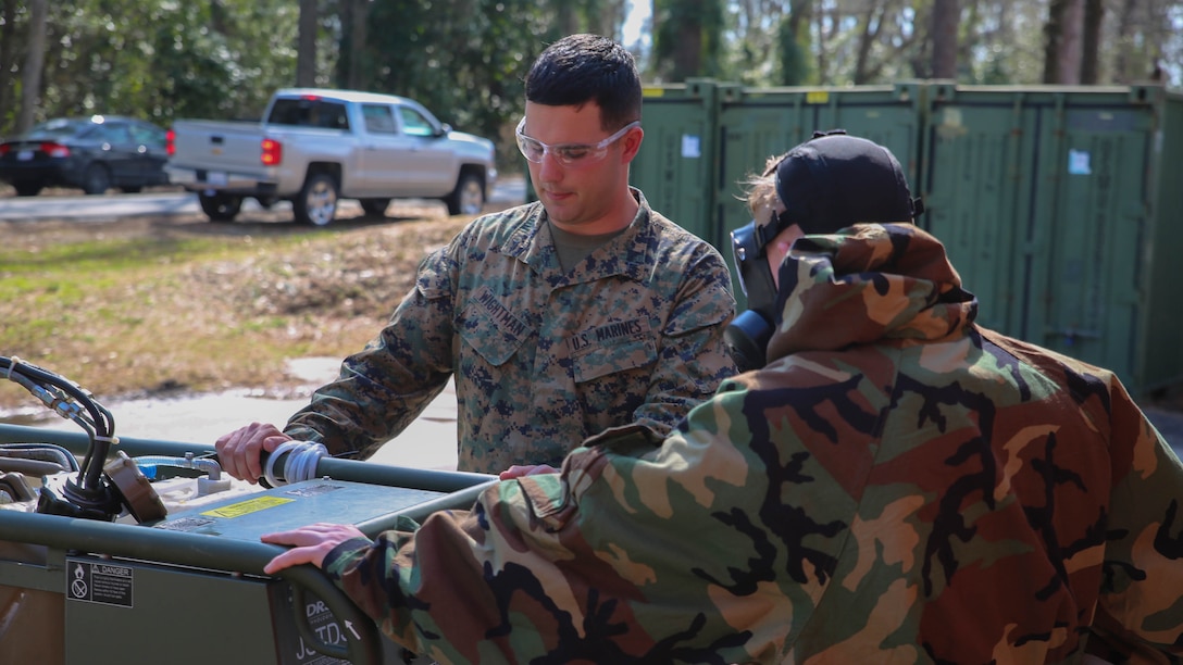 Lance Cpl. Brian Wightman (left), a chemical, biological, radiological and nuclear defense specialist with Headquarters Regiment, 2nd Marine Logistics Group discusses start-up procedures of the M26 Joint Service Transportable Decontamination System during a CBRN decontamination course aboard Camp Lejeune, N.C., March 4, 2015. The M26 uses hot, pressurized water to decontaminate personnel, equipment and vehicles.