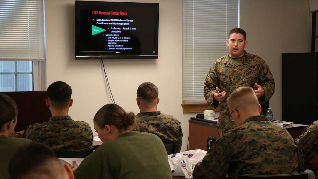 Corporal Matthew Villalba, a chemical, biological, radiological and nuclear defense specialist with Headquarters Regiment, 2nd Marine Logistics Group, discusses defense procedures of a CBRN attack during a CBRN decontamination course aboard Camp Lejeune, N.C., March 3, 2015. Students attending the week-long course learned a variety of CBRN defense and decontamination procedures to provide assistance in the event of a CBRN attack or disaster.