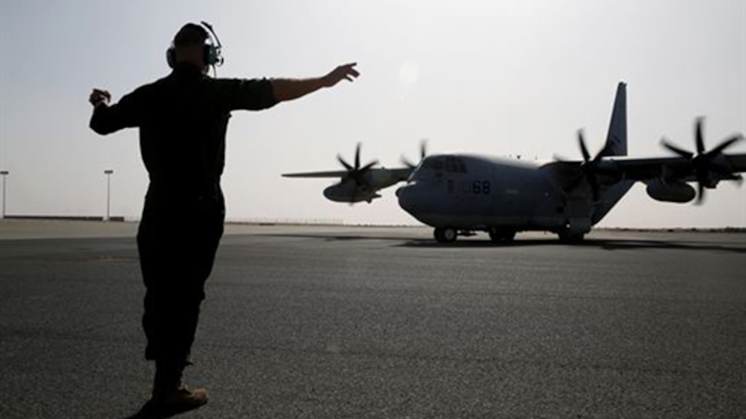 A U.S. Marine with Marine Aerial Refueler Transport Squadron 352, Special Purpose Marine Air Ground Task Force – Crisis Response – Central Command, directs a KC-130J Hercules aircraft to the runway before takeoff in the Central Command area of operations, Feb. 23, 2015. The Marines, sailors and aircraft with VMGR 352 support SPMAGTF – CR – CC by transporting supplies, equipment and personnel to various locations in the region.