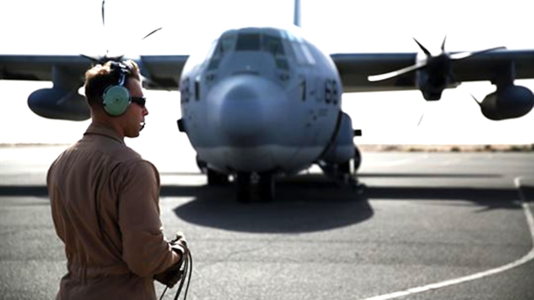 A U.S. Marine aircraft crewman with Marine Aerial Refueler Transport Squadron 352, Special Purpose Marine Air Ground Task Force – Crisis Response – Central Command, performs pre-flight checks on a KC-130J Hercules aircraft before takeoff in the Central Command area of operations, Feb. 23, 2015. The Marines, sailors and aircraft with VMGR 352 support SPMAGTF – CR – CC by transporting supplies, equipment, and personnel to various locations in the region.