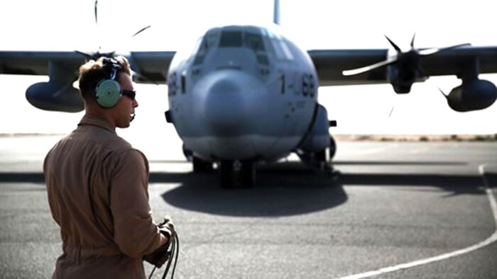 A U.S. Marine aircraft crewman with Marine Aerial Refueler Transport Squadron 352, Special Purpose Marine Air Ground Task Force – Crisis Response – Central Command, performs pre-flight checks on a KC-130J Hercules aircraft before takeoff in the Central Command area of operations, Feb. 23, 2015. The Marines, sailors and aircraft with VMGR 352 support SPMAGTF – CR – CC by transporting supplies, equipment, and personnel to various locations in the region.