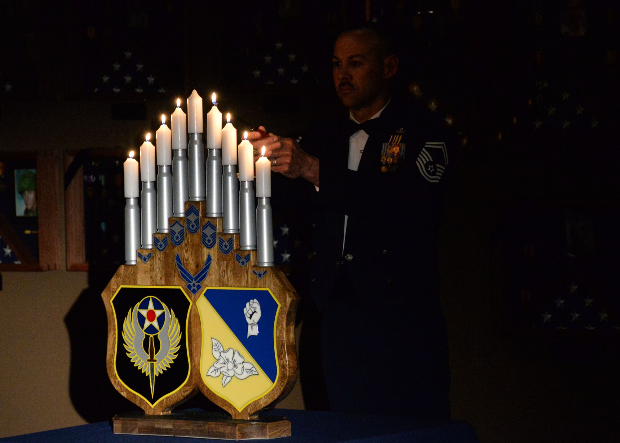 A U.S. Air Force senior master sergeant lights the eighth candle during the candle ceremony at the Chief Master Sergeant Recognition Ceremony, March 4, 2015 at Cannon Air Force Base, N.M. The Career Compensation Act of 1958 allowed Congress to limit the Air Force in promoting two percent of the enlisted force to the grade of senior master sergeant and one percent to the grade of chief master sergeant. (U.S. Air Force photo/Staff Sgt. Alexxis Mercer)