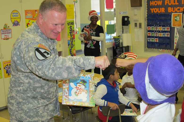 Huntsville Center Commander, Col. Robert Ruch, shares fist bump with student as he hands out free books at Rolling Hills Elementary School.                     