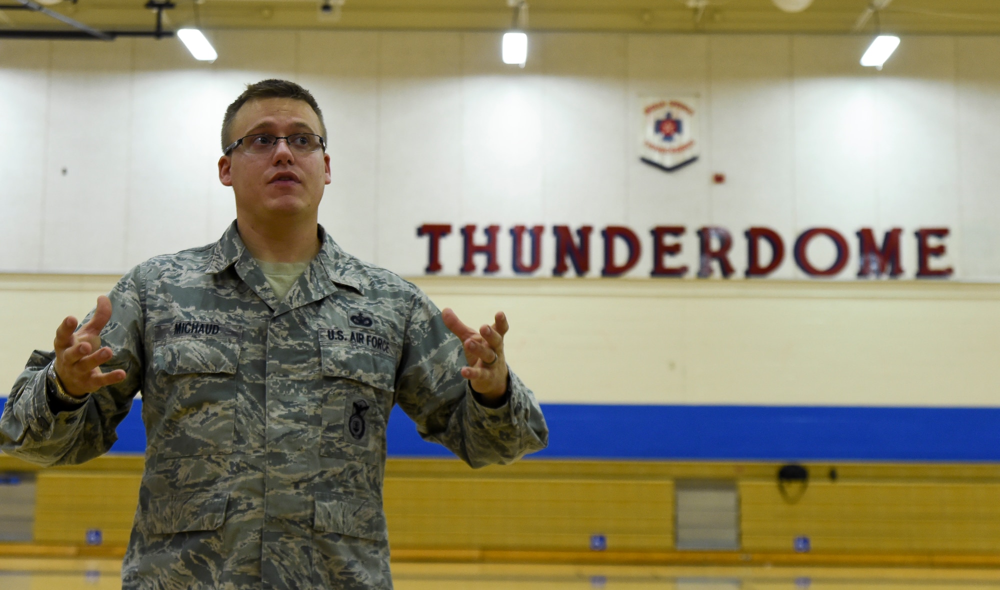 Staff Sgt. Christopher Michaud, 799th Security Forces Squadron kennel master, answers student’s questions during a K9 demonstration inside the Indian Springs Schools gymnasium March 2, 2014. The demonstration was part of a Nevada Reading Week event for Indian Springs Elementary School students. (U.S. Air Force photo by Tech. Sgt. Shad Eidson/released)