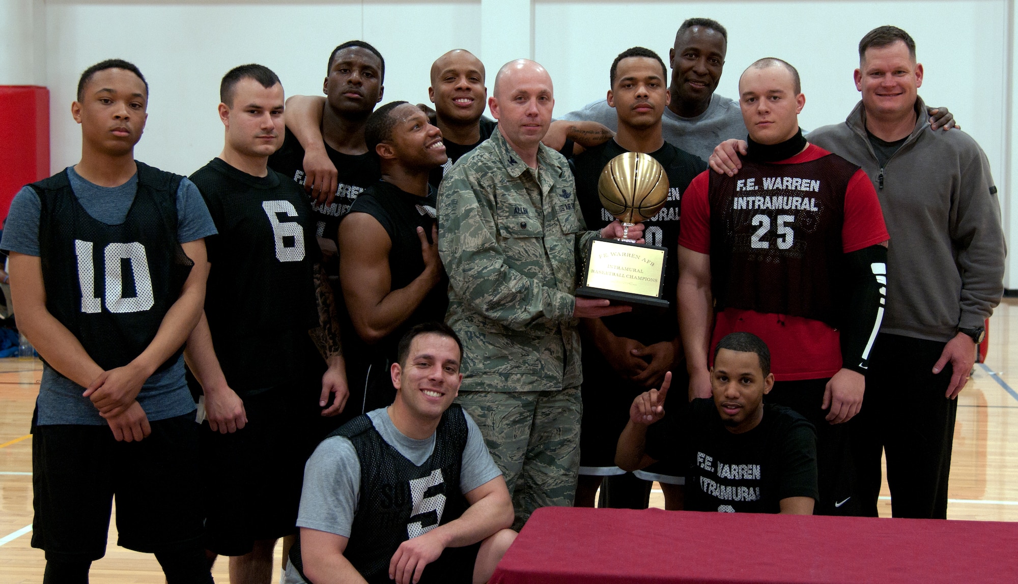 Col. Ron Allen Jr. presents the Intramural Basketball Championship Trophy to the Security Forces Group Intramural Basketball Team after their win against the 90th Force Support Squadron Basketball Team March 4, 2015, in the Freedom Hall Fitness Center on F.E. Warren Air Force Base, Wyo. The 90th SFG team won the championship game with a score of 58 against the 90th FSS team who scored 49. (U.S. Air Force photo by Airman 1st Class Malcolm Mayfield)