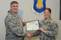 Col. Albert Miller, 22nd Air Refueling Wing commander, poses with Staff Sgt. Chelsie McCall, 22nd Air Refueling Wing safety technician, March 6, 2015, at McConnell Air Force Base, Kan. McCall was selected as the spotlight performer for the week of Feb 8 through 14 for completing her nine months of career development courses in just six weeks. (U.S. Air Force photo by Airman 1st Class Christopher Thornbury)