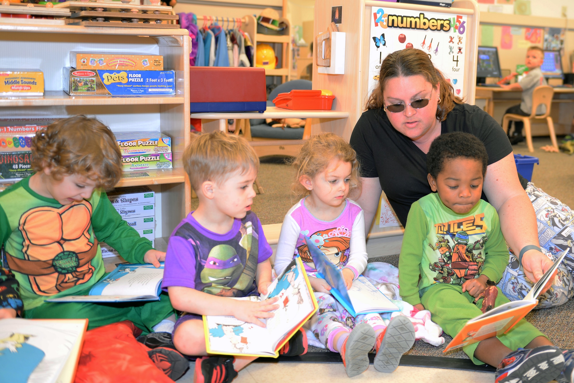 Ali Stasiulis, Child Development Center II program assistant, reads to children from the 3-year-old class for Pajama Day as part of Dr. Seuss Week March 5, 2015, at Moody Air Force Base, Ga. Staff members and students were encouraged to dress in their silliest pajama attire and read Dr. Seuss stories. (U.S. Air Force photo by Airman Greg Nash/Released)