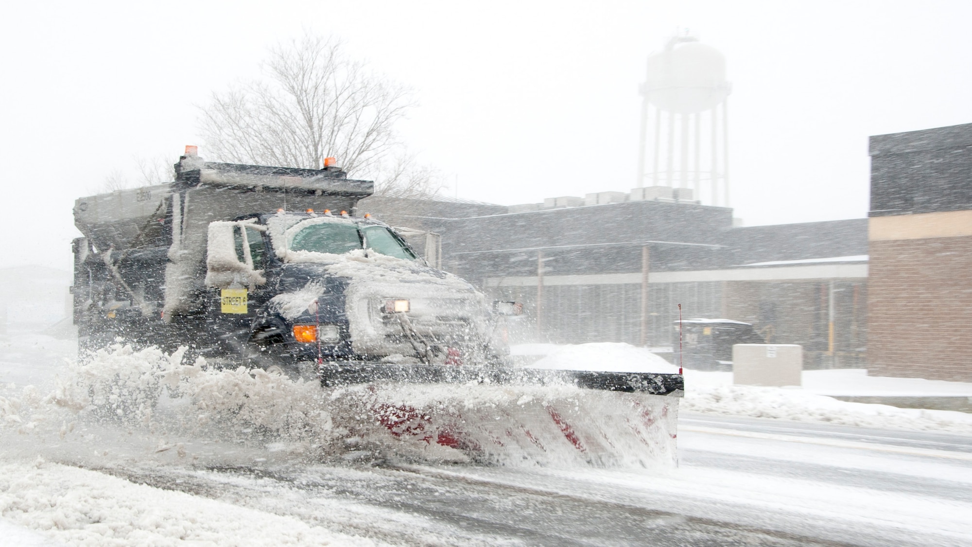 A dump truck snow plow clears snow from Purple Heart Drive during a snow storm March 5, 2015, on Dover Air Force Base, Del. This dump truck was a part of a team of five plows which cleared as much snow as possible off the base’s streets. (U.S. Air Force photo/Senior Airman Jared Duhon) 