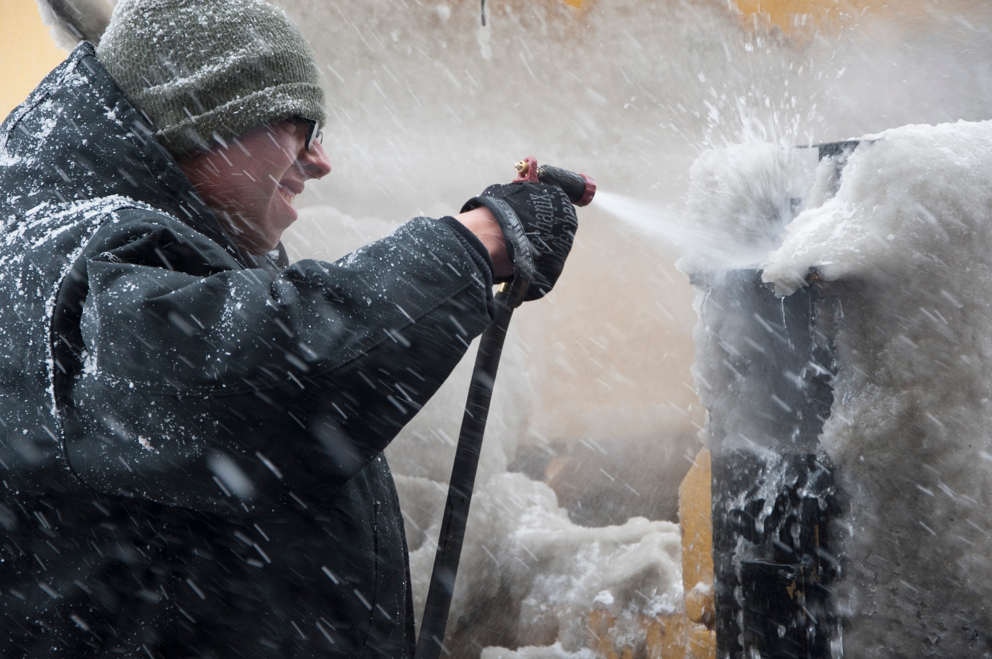 Airman 1st Class Jeremy Johnson, 436th Civil Engineer Squadron snow operations, sprays off snow and ice left after plowing the runway March 5, 2015, at Dover Air Force Base, Del. Johnson is assigned to the Civil Engineer Squadron’s “Snow Barn” to help keep the Team Dover’s runways and streets clear of snow. (U.S. Air Force photo/Senior Airman Jared Duhon) 