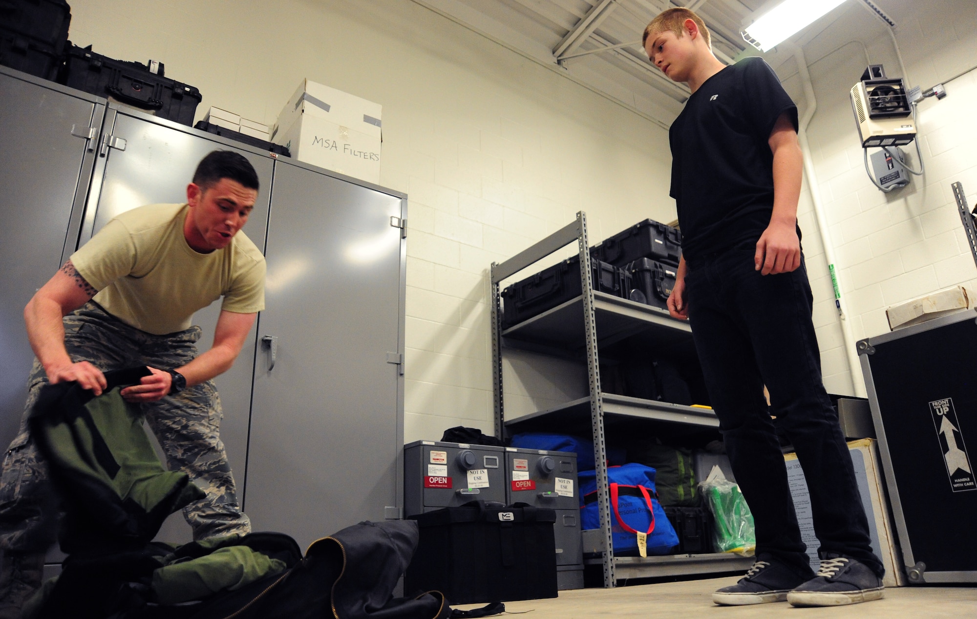 Senior Airman Robert Sutton, 509th Civil Engineer Squadron explosive ordinance disposal technician, gives a demonstration to Gage Baska, a 14 year-old resident of Blue Springs, Mo., on an EOD-9 Alpha bomb suit at Whiteman Air Force Base, Mo., Nov. 5, 2014. Baska received the demonstration as part of an intervention program he is participating in. (U.S. Air Force photo by Staff Sgt. Nick Wilson/Released) 