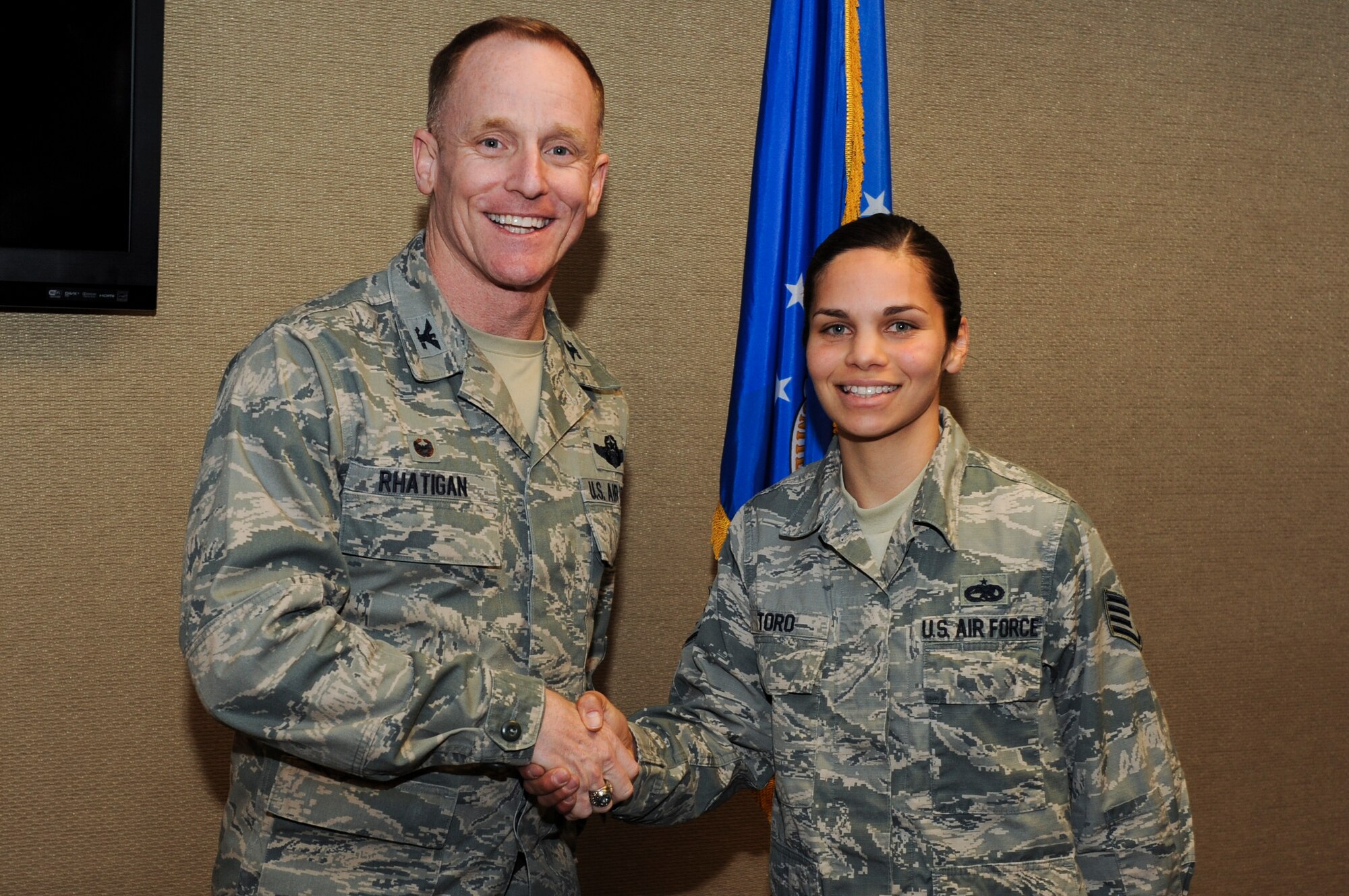 Col. Patrick Rhatigan, the 19th Airlift Wing commander, congratulate Staff Sgt. Glorimar Toro, a 373rd Training Squadron aerospace maintenance instructor, for her selection as Combat Airlifter of the Week March 2, 2015, at Little Rock Air Force Base, Ark. Toro, a Farmington Hills, Mich., native scheduled 87 classes for a total of 9,672 instructional hours. (U.S. Air Force photo/Senior Airman Cliffton Dolezal)