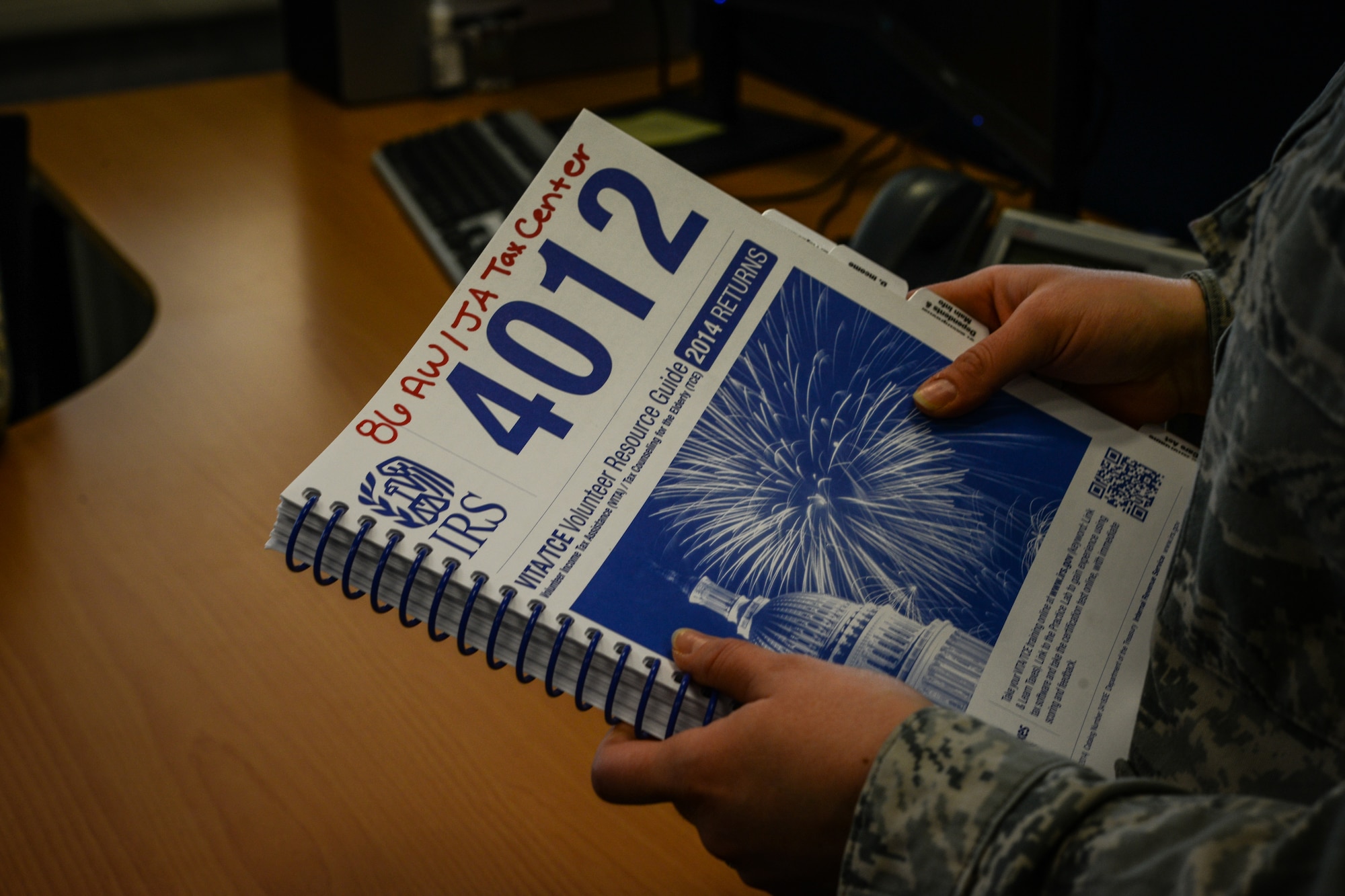 Senior Airman Alexy Doran, 86th Civil Engineer Squadron emergency management journeyman, references a tax return guide at Ramstein Air Base, Germany, March 6, 2015. More than 60 volunteers work diligently, crunching numbers to save Airmen money through the months of February to June.   (U.S. Air Force photo/Senior Airman Nicole Sikorski)