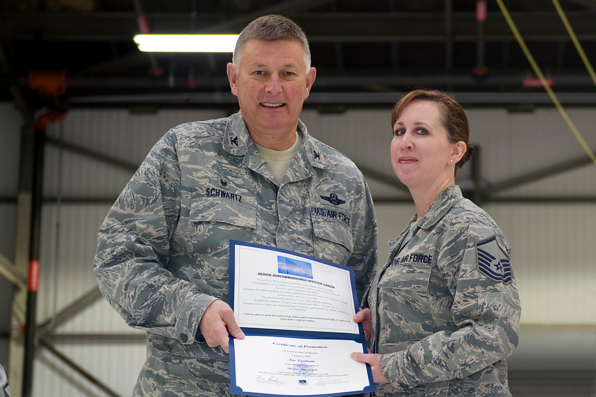 Master Sgt. Ane Graham, 434th Air Refueling Wing financial management technician, is presented with a certificate of promotion by Col. Doug Schwartz, 434th Air Refueling Wing commander, during a non-commissioned officer induction ceremony at Grissom Air Reserve Base, Ind., Feb. 7, 2015. Graham along with one other master sergeant and four staff sergeants were inducted in the ranks of NCO and senior NCO. (U.S. Air Force photo/ Senior Airman Jami K. Lancette)