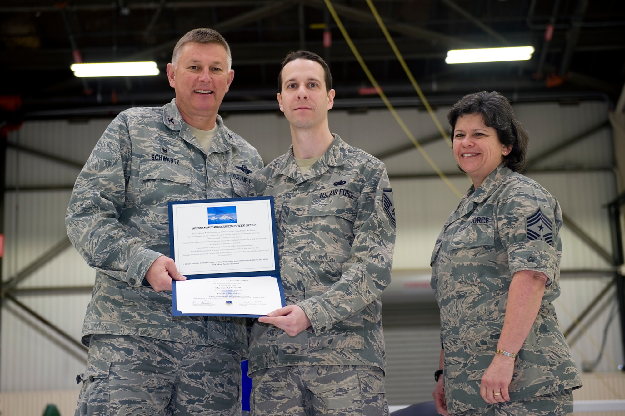 Master Sgt. Michael Darnell, 434th Logistics Readiness Squadron supply management craftsman, is presented with a certificate of promotion by Col. Doug Schwartz, 434th Air Refueling Wing commander, and Chief Master Sgt. Karen Perkins, 434th ARW command chief, during a non-commissioned officer induction ceremony at Grissom Air Reserve Base, Ind., Feb. 8, 2015. Darnell along with one other master sergeant and four staff sergeants were inducted in the ranks of NCO and senior NCO. (U.S. Air Force photo/ Senior Airman Jami K. Lancette)