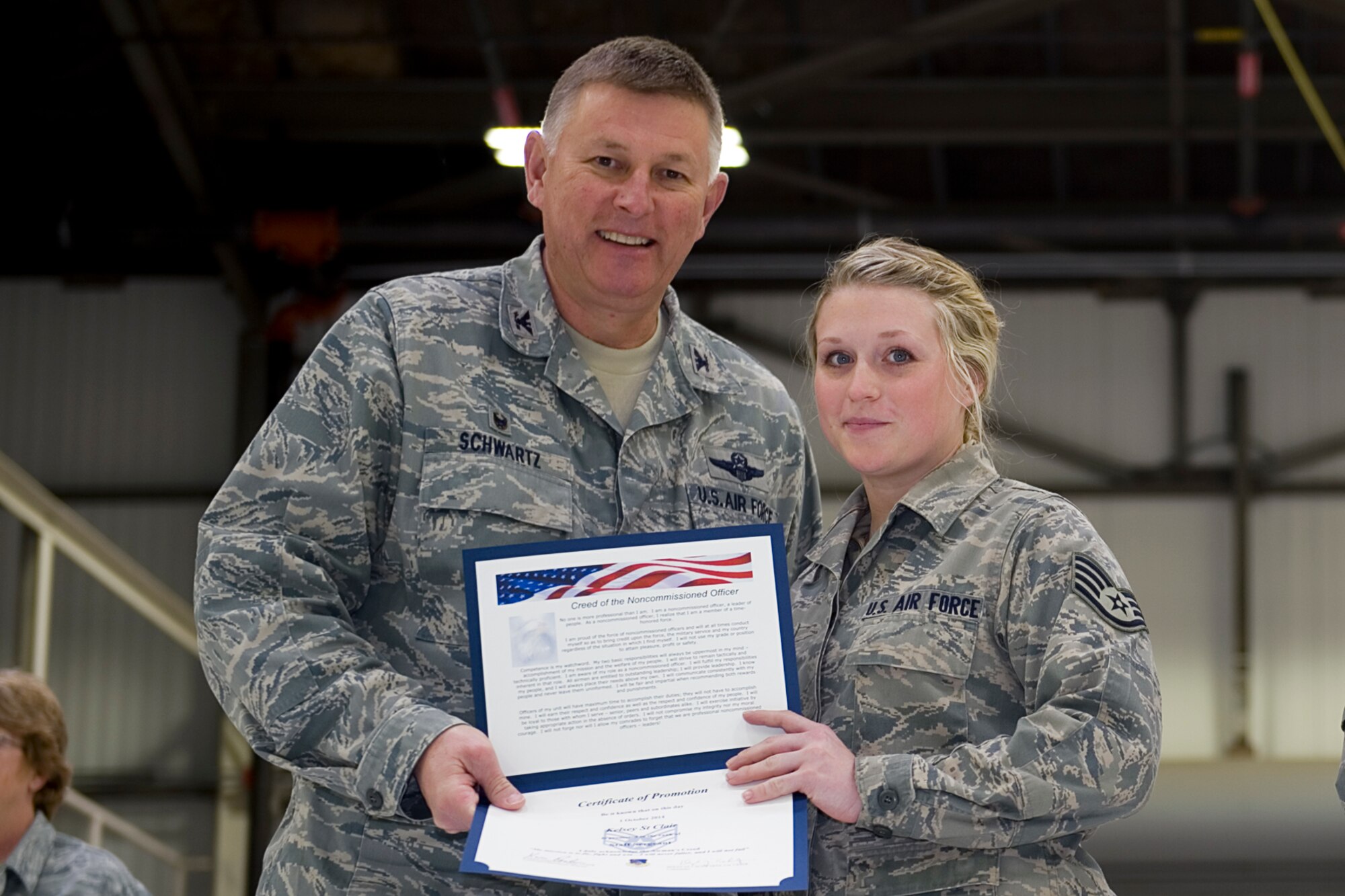 Staff Sgt. Kelsey St. Clair, 434th Maintenance Squadron crew chief, is presented with a certificate of promotion by Col. Doug Schwartz, 434th Air Refueling Wing commander, during a non-commissioned officer induction ceremony at Grissom Air Reserve Base, Ind., Feb. 8, 2015. St. Clair along with three staff sergeants and two master sergeants were inducted in the ranks of NCO and senior NCO. (U.S. Air Force photo/ Senior Airman Jami K. Lancette)