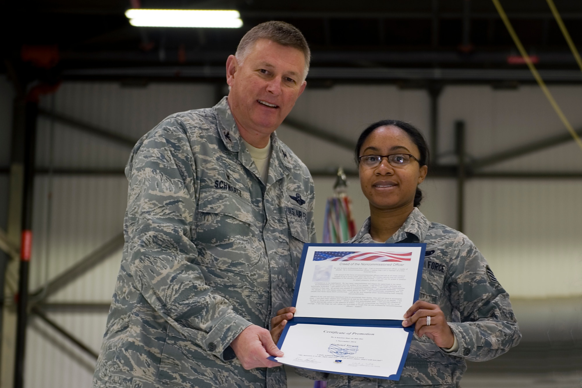 Staff Sgt. Brandy Brown, 434th Logistics Readiness Squadron material management apprentice, is presented with a certificate of promotion by Col. Doug Schwartz, 434th Air Refueling Wing commander, during a non-commissioned officer induction ceremony at Grissom Air Reserve Base, Ind., Feb. 7, 2015. Brown along with three staff sergeants and two master sergeants were inducted in the ranks of NCO and senior NCO. (U.S. Air Force photo/ Senior Airman Jami K. Lancette)