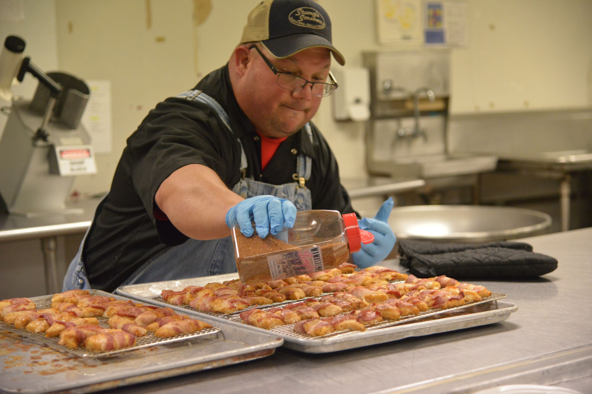 Walter Stump McDowell seasons bacon-wrapped swai for the appetizer course during the Airman Chef Competition. (U.S. Air Force photo by Ray Crayton)