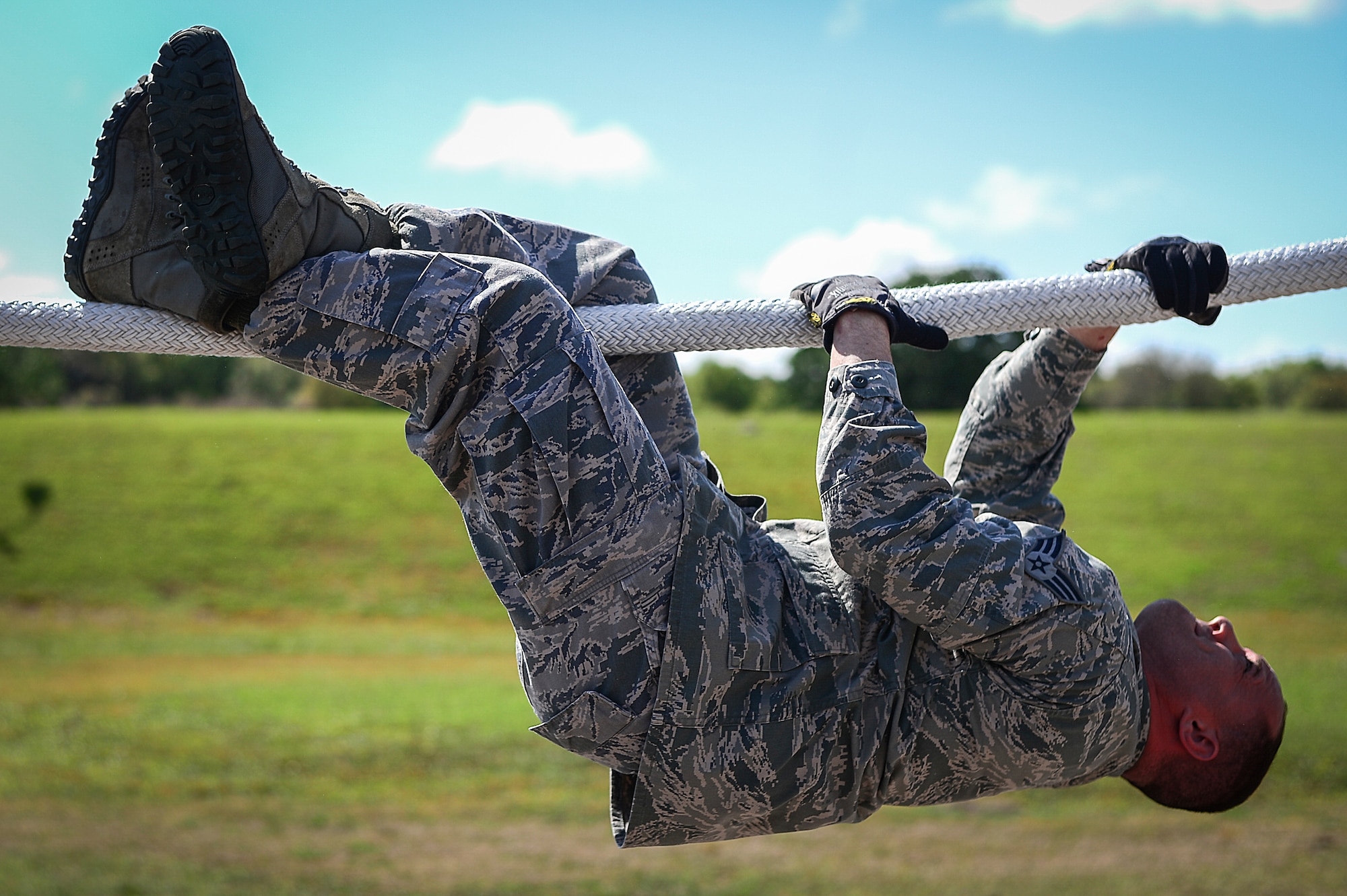 Senior Airman Rob Carlisto, Joint Communications Support Element cyber support, pulls himself across a rope obstacle at the Hillsborough County Sheriff’s Office firearms training center in Lithia, Fla., March 3, 2015. Members of the JCSE completed the obstacle course before the stress fire portion of Warrior Spirit ’15. (U.S. Air Force photo by Senior Airman Ned T. Johnston/Released)