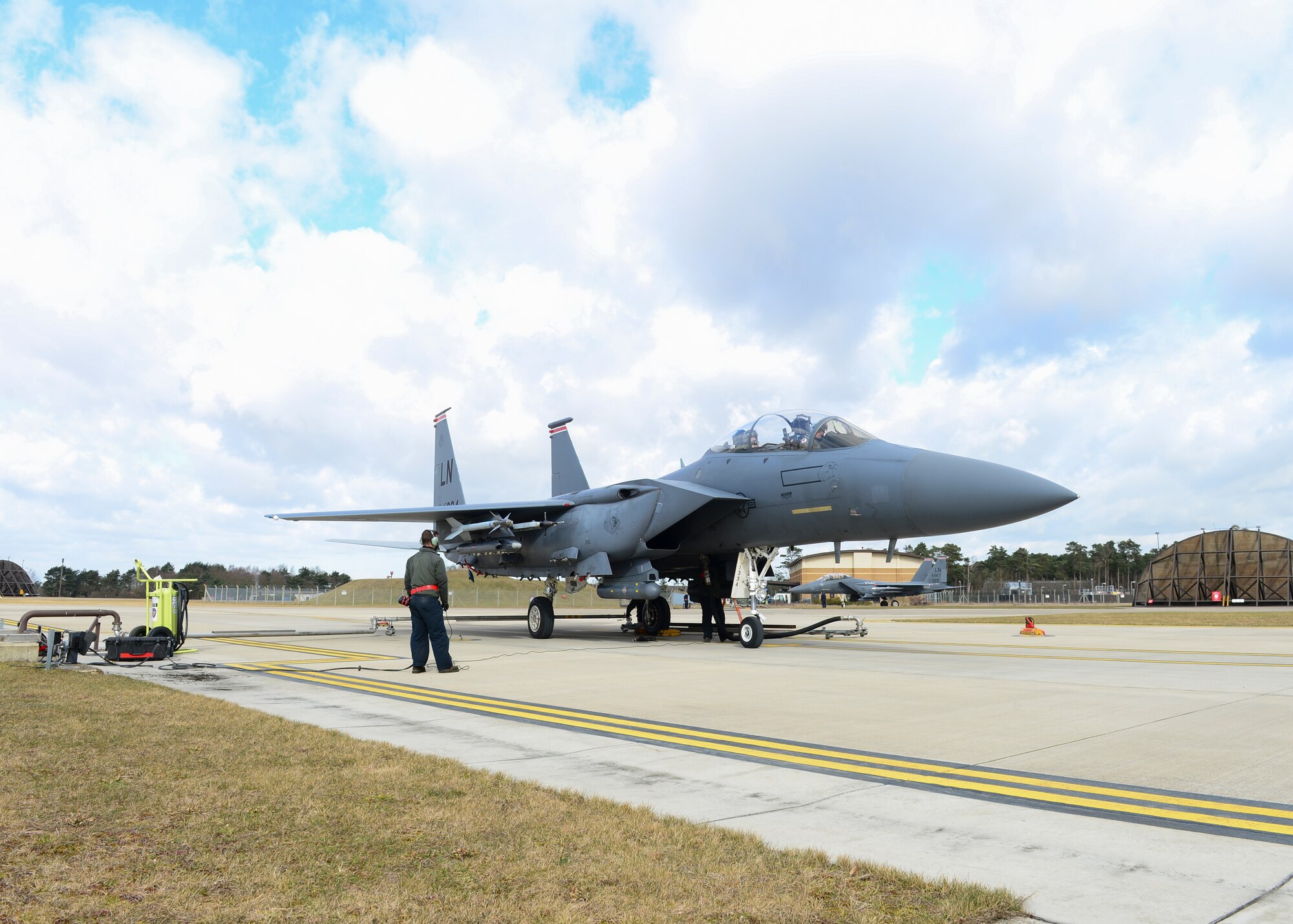 Airmen of the 48th Fighter Wing use hot pit systems to refuel F-15C Eagles at Royal Air Force Lakenheath, England, Mar. 4, 2015. Hot-pit refueling systems give aircrafts the ability to land and refuel with engines still running, similar to a stock car making a pit stop in NASCAR. (U.S. Air Force photo by Senior Airman Nigel Sandridge/Released)