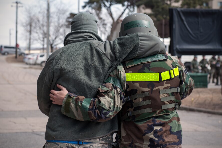 Medical Airmen assist a simulated victim from a simulated missile attack during an Exercise Beverly Midnight 15-2 scenario at Kunsan Air Base, Republic of Korea, March 4, 2015. BM 15-2 tests Airmen on their ability to survive and operate while under the stress of simulated wartime activities. (U.S. Air Force photo by Senior Airman Taylor Curry/Released) 
