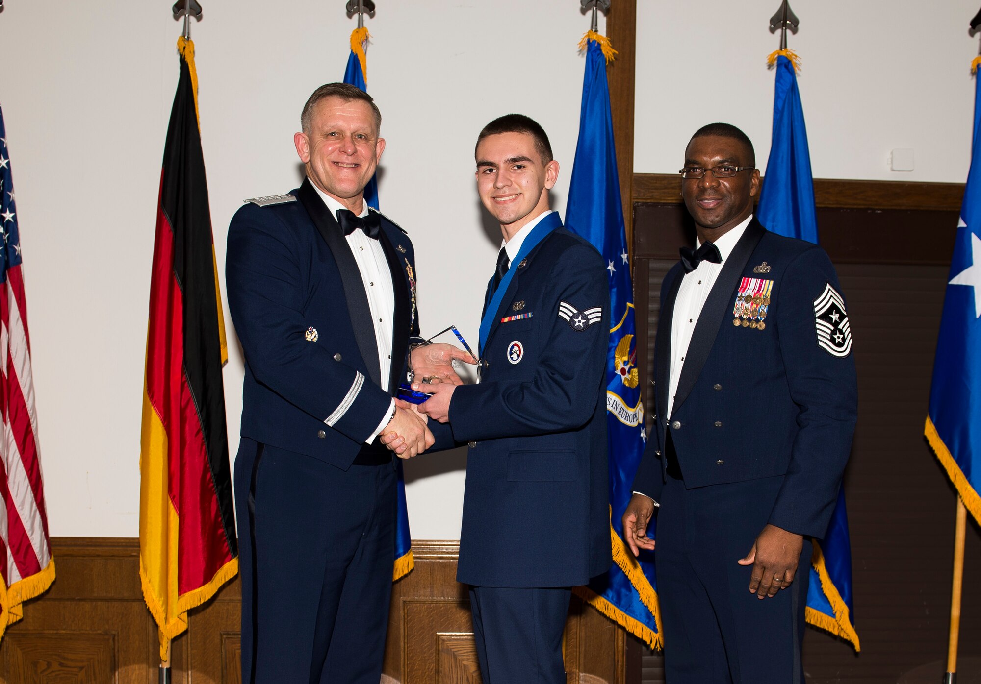 Senior Airman Michael McBride, 606th Air Control Squadron cyber transport technician, receives his U.S. Air Forces in Europe and Air Forces Africa Honor Guardsmen of the Year award from Gen. Frank Gorenc, USAFE-AFAFRICA commander and Chief Master Sgt. James E. Davis, USAFE-AFAFRICA command chief, during an annual awards ceremony at Ramstein Air Base Germany, March 5, 2015. The Airmen competed within their units, then at the wing level and have now been named the best in USAFE-AFAFRICA. They will go on to compete at the Air Force level for the coveted Outstanding Airmen of the Year award which will be announced later this year. (U.S. Air Force photo/ Senior Airman Damon Kasberg)
