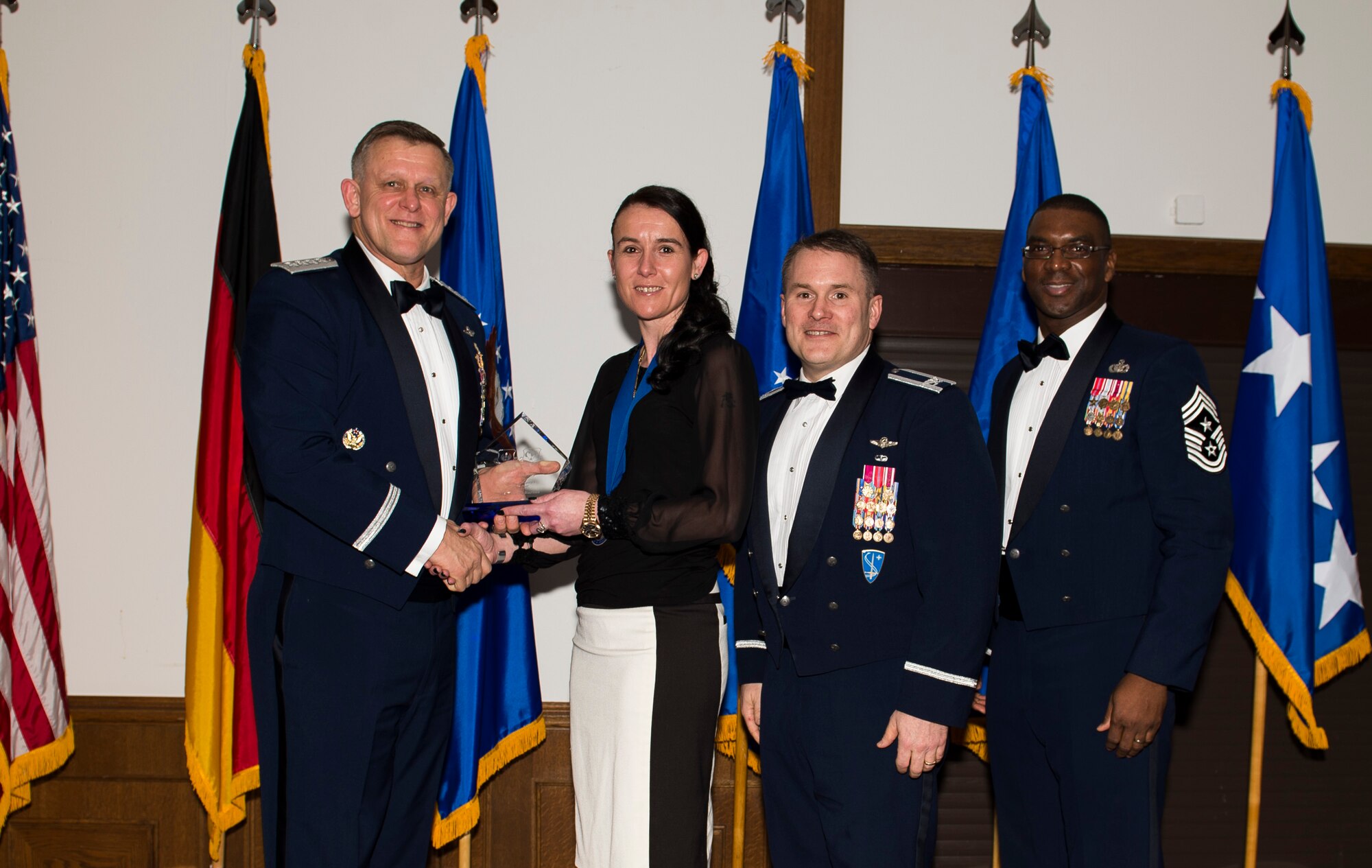 Mrs. Tina Barnes, 48th Security Forces Squadron pass and registration supervisor, receives her U.S. Air Forces in Europe and Air Forces Africa Civilian Category One of the Year award from Gen. Frank Gorenc, USAFE-AFAFRICA commander and Chief Master Sgt. James E. Davis, USAFE-AFAFRICA command chief, during an annual awards ceremony at Ramstein Air Base Germany, March 5, 2015. The Airmen competed within their units, then at the wing level and have now been named the best in USAFE-AFAFRICA. They will go on to compete at the Air Force level for the coveted Outstanding Airmen of the Year award which will be announced later this year. (U.S. Air Force photo/ Senior Airman Damon Kasberg)