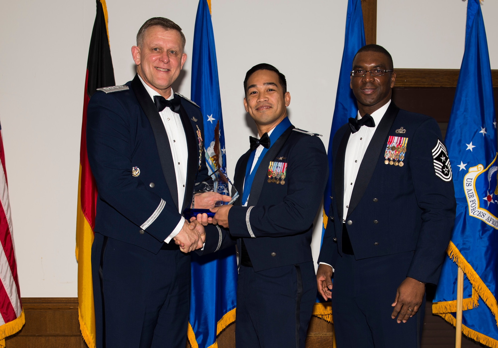 Capt. Ira Feliciano, 423rd Communications Squadron director of operations, receives his U.S. Air Forces in Europe and Air Forces Africa Company Grade Officer of the Year award from Gen. Frank Gorenc, USAFE-AFAFRICA commander and Chief Master Sgt. James E. Davis, USAFE-AFAFRICA command chief, during an annual awards ceremony at Ramstein Air Base Germany, March 5, 2015. The Airmen competed within their units, then at the wing level and have now been named the best in USAFE-AFAFRICA. They will go on to compete at the Air Force level for the coveted Outstanding Airmen of the Year award which will be announced later this year. (U.S. Air Force photo/ Senior Airman Damon Kasberg)