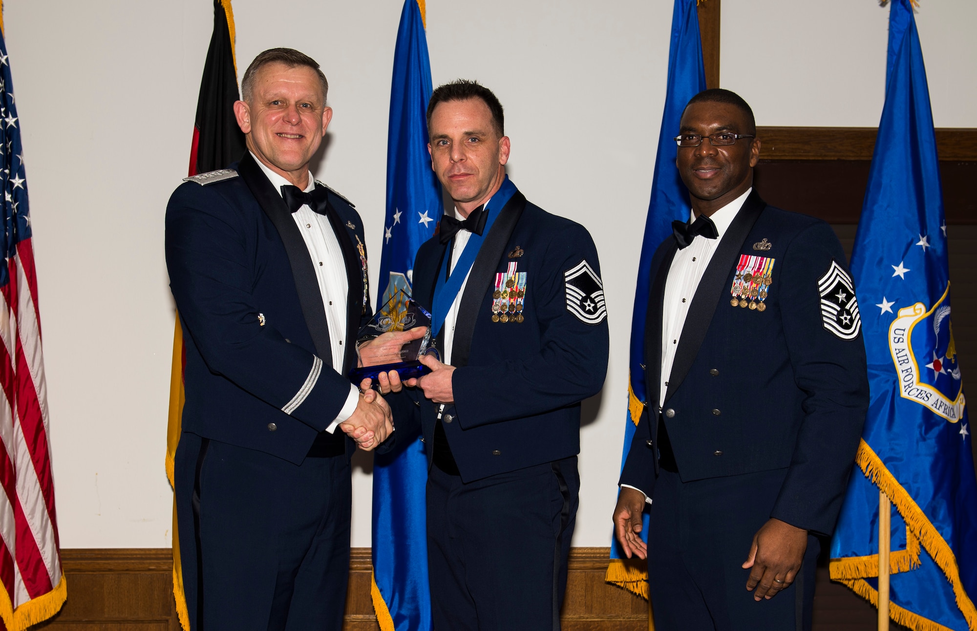 Senior Master Sgt. Marcus Webb, 501st Combat Support Wing staff agencies superintendent, receives his U.S. Air Forces in Europe and Air Forces Africa Senior NCO of the Year award from Gen. Frank Gorenc, USAFE-AFAFRICA commander and Chief Master Sgt. James E. Davis, USAFE-AFAFRICA command chief, during an annual awards ceremony at Ramstein Air Base Germany, March 5, 2015. Airmen competed within their units, then at the wing level and have now been named the best in USAFE-AFAFRICA. They will go on to compete at the Air Force level for the coveted Outstanding Airmen of the Year award which will be announced later this year. (U.S. Air Force photo/ Senior Airman Damon Kasberg)
