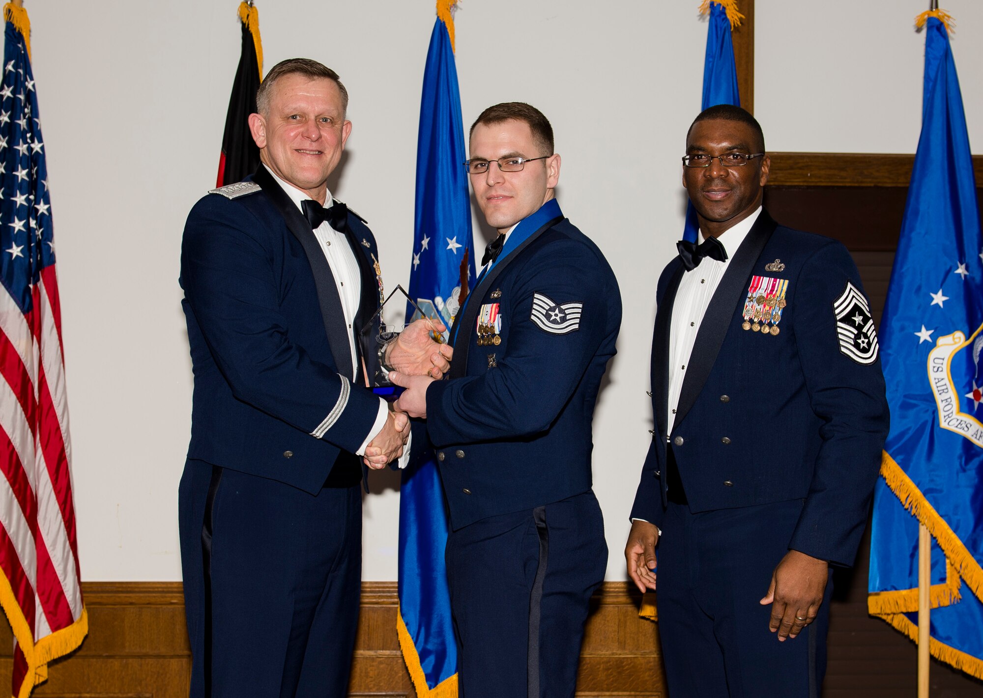 Tech. Sgt. David Ordway, 100th Civil Engineer Squadron fire protection station chief, receives his U.S. Air Forces in Europe and Air Forces Africa NCO of the Year award from Gen. Frank Gorenc, USAFE-AFAFRICA commander and Chief Master Sgt. James E. Davis, USAFE-AFAFRICA command chief, during an annual awards ceremony at Ramstein Air Base Germany, March 5, 2015. Airmen competed within their units, then at the wing level and have now been named the best in USAFE-AFAFRICA. They will go on to compete at the Air Force level for the coveted Outstanding Airmen of the Year award which will be announced later this year. (U.S. Air Force photo/ Senior Airman Damon Kasberg)