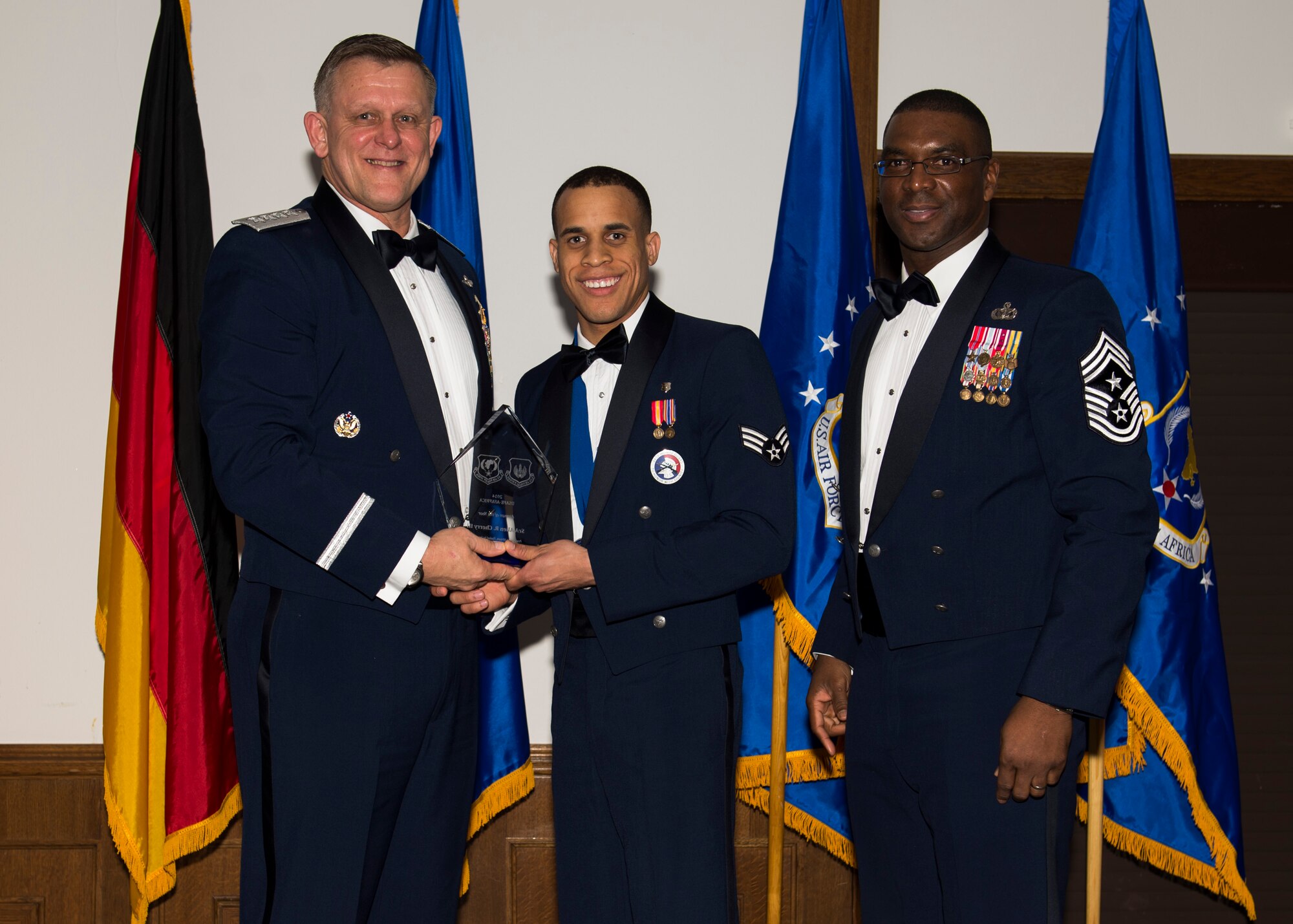 Senior Airman Allen Cherry III, 86th Aerospace Medicine Squadron public health technician, receives his U.S. Air Forces in Europe and Air Forces Africa Airman of the Year award from Gen. Frank Gorenc, USAFE-AFAFRICA commander and Chief Master Sgt. James E. Davis, USAFE-AFAFRICA command chief, during an annual awards ceremony at Ramstein Air Base Germany, March 5, 2015. Airmen competed within their units, then at the wing level and have now been named the best in USAFE-AFAFRICA. They will go on to compete at the Air Force level for the coveted Outstanding Airmen of the Year award which will be announced later this year. (U.S. Air Force photo/ Senior Airman Damon Kasberg)