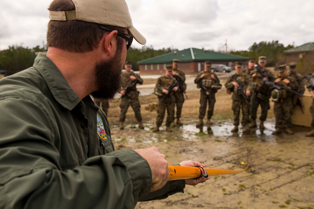 A training specialist with the Marine Corps Engineer School demonstrates how to use a holley stick to Marines with Alpha Company, 2nd Combat Engineer Battalion, 2nd Marine Division during the practical application portion of a week-long Counter-IED course aboard Marine Corps Base Camp Lejeune, N.C., March 2-5, 2015. A holley stick is a long metal rod utilized by combat engineer Marines that allows them to feel for any wires that are attached to an IED. It is implemented by scraping along the ground and entrances to compounds for trip wires that could detonate any IEDs. (U.S. Marine Corps photo by Cpl. Krista James/Released)
