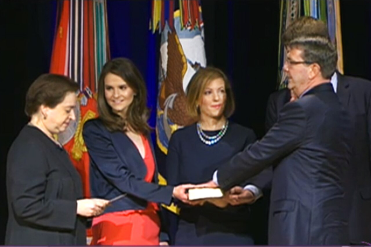 Supreme Court Justice Elena Kagan administers the oath of office to Defense Secretary Ash Carter as his wife, Stephanie, holds the Bible and their children, Ava and Will, look on during a ceremonial swearing-in at the Pentagon, March 6, 2015. Vice President Joe Biden officially swore in Carter as the 25th secretary of defense last month. DoD screen shot