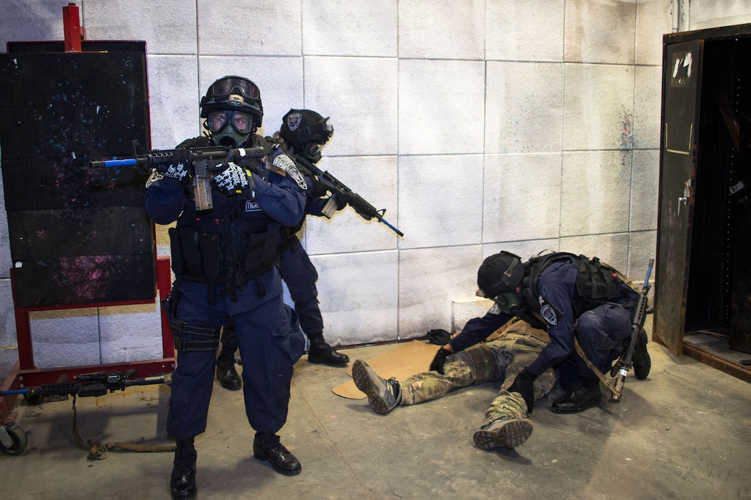 A Honduran commando searches an enemy combatant played by a Green Beret while other commandos provide security during battle training on Eglin Air Force Base, Fla., Feb. 25, 2015.