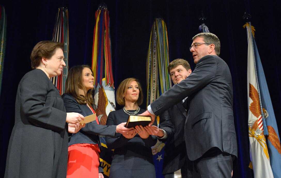 Supreme Court Justice Elena Kagan administers the oath of office to Defense Secretary Ash Carter as his wife, Stephanie, holds the Bible and their children, Ava and Will, look on during a ceremonial swearing-in at the Pentagon, March 6, 2015. 