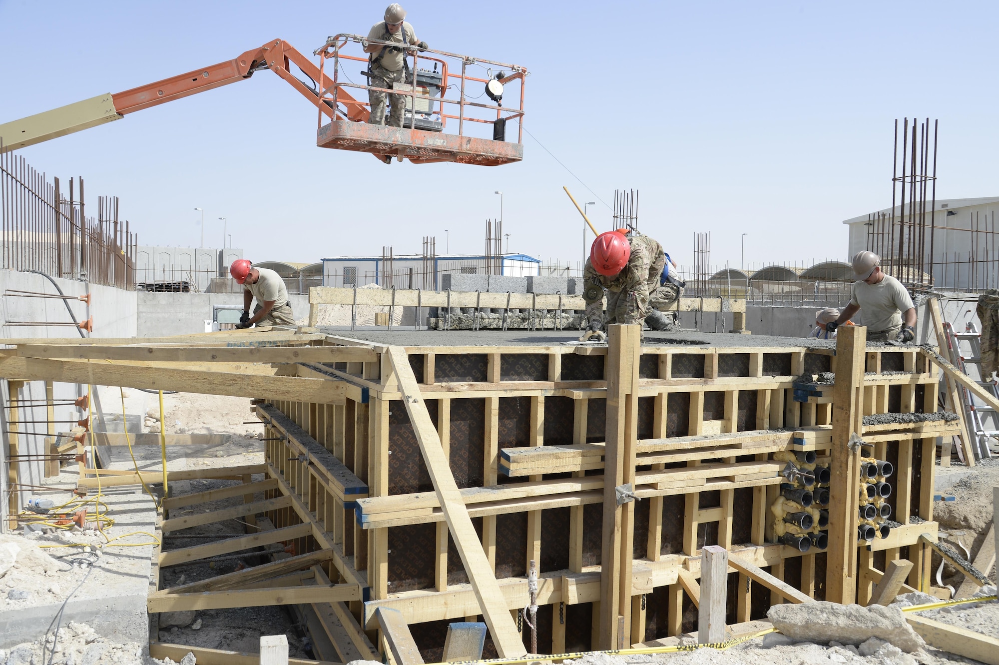 Airmen with the Expeditionary Prime Base Engineer Emergency Force Squadron work on a concrete electrical vault at an undisclosed location in Southwest Asia Mar. 4, 2015. The EPBS has been working on several base projects to include replacing $280K worth of new showers in the Army barracks.  (U.S. Air Force photo/Tech. Sgt. Marie Brown) (RELEASED)