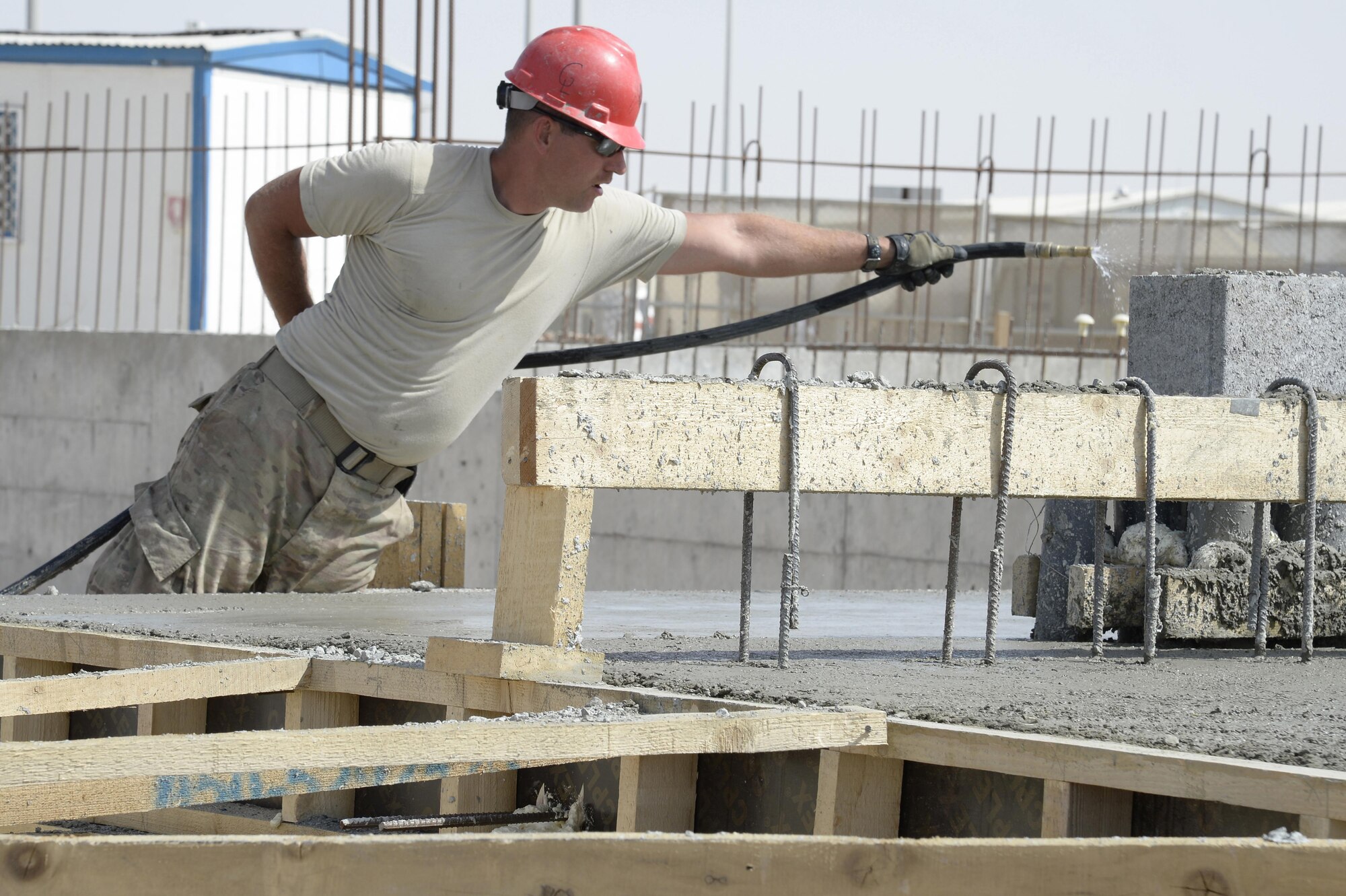 Tech. Sgt. Steven, Expeditionary Prime Base Engineer Emergency Force Squadron engineering assistant, wets down concrete at a construction site at an undisclosed location in Southwest Asia Mar. 4, 2015. The EPBS has been working on several base projects to include constructing a 13.5’x13.5’x8’, 12-inch thick concrete electrical vault and 31 foot reinforced horizontal stem wall for the Communications Squadron. Steven is currently deployed from the 183rd Civil Engineer Squadron out of Abraham Lincoln Capital Airport in Springfield, Ill. (U.S. Air Force photo/Tech. Sgt. Marie Brown) (RELEASED)