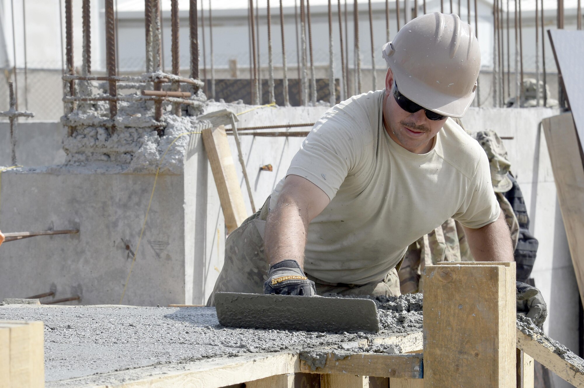Tech. Sgt. Philip, Expeditionary Prime Base Engineer Emergency Force Squadron water and fuels systems manager, smooth’s out concrete at a construction site at an undisclosed location in Southwest Asia Mar. 4, 2015. Prime BEEF provides installation support by focusing on managing real property, facilities and infrastructure on U.S. or enduring bases in geographic combatant commands outside the U.S. Philip is currently deployed from the 183rd Civil Engineer Squadron out of Abraham Lincoln Capital Airport in Springfield, Ill. (U.S. Air Force photo/Tech. Sgt. Marie Brown) (RELEASED)