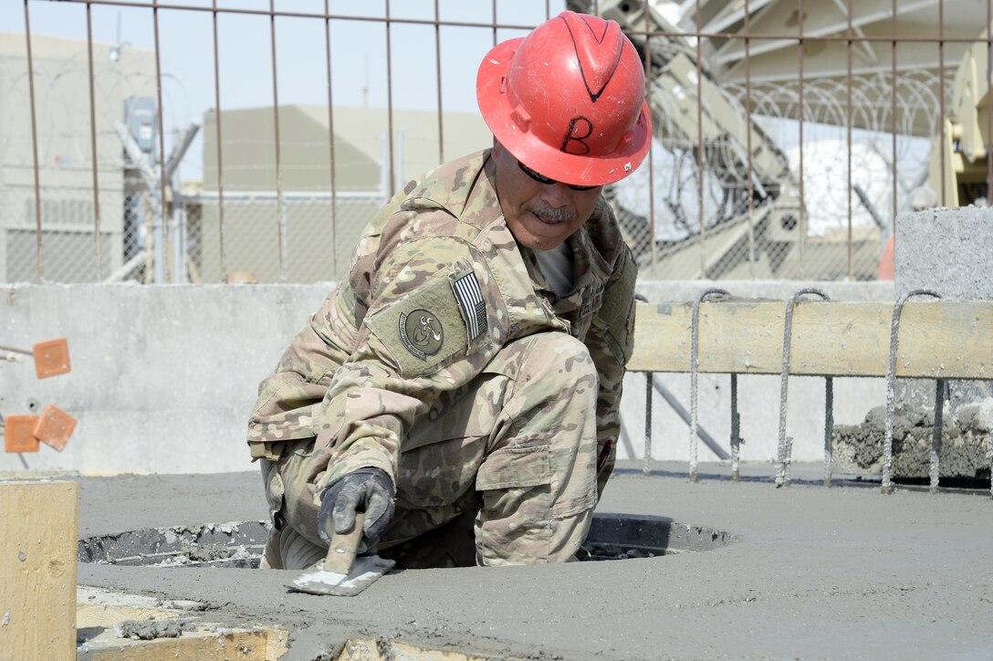 Master Sgt. Sergio, Expeditionary Prime Base Engineer Emergency Force Squadron water and fuels systems manager, smooth’s out concrete at a construction site at an undisclosed location in Southwest Asia Mar. 4, 2015. EPBS does stand-alone small to medium construction projects, from programming to real estate capitalization as well as working with larger units such as Red Horse, Seabees and Army engineer battalions to build large scale projects. Serfio is currently deployed from the 161st Civil Engineer Squadron out of Sky Harbor Air National Guard Base, Phoenix, Ariz. (U.S. Air Force photo/Tech. Sgt. Marie Brown) (RELEASED)