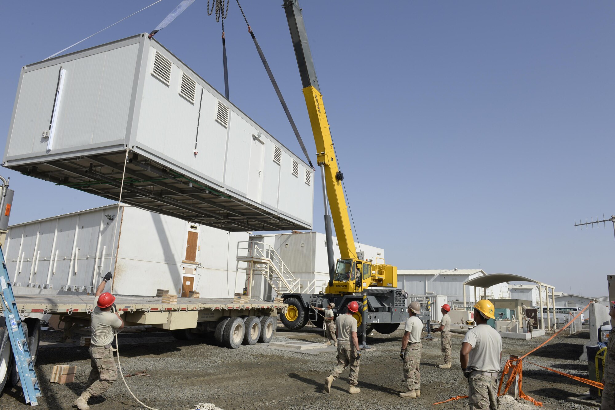 Airmen with the Expeditionary Prime Base Engineer Emergency Force Squadron work together to lower a new shower cadillac into place at an undisclosed location in Southwest Asia Mar. 4, 2015. EPBS does cradle to grave construction consisting of small to medium construction projects from programming to real estate capitalization. Greenleaf is currently deployed from the 183rd Civil Engineer Squadron out of Abraham Lincoln Capital Airport in Springfield, Ill. (U.S. Air Force photo/Tech. Sgt. Marie Brown) (RELEASED)