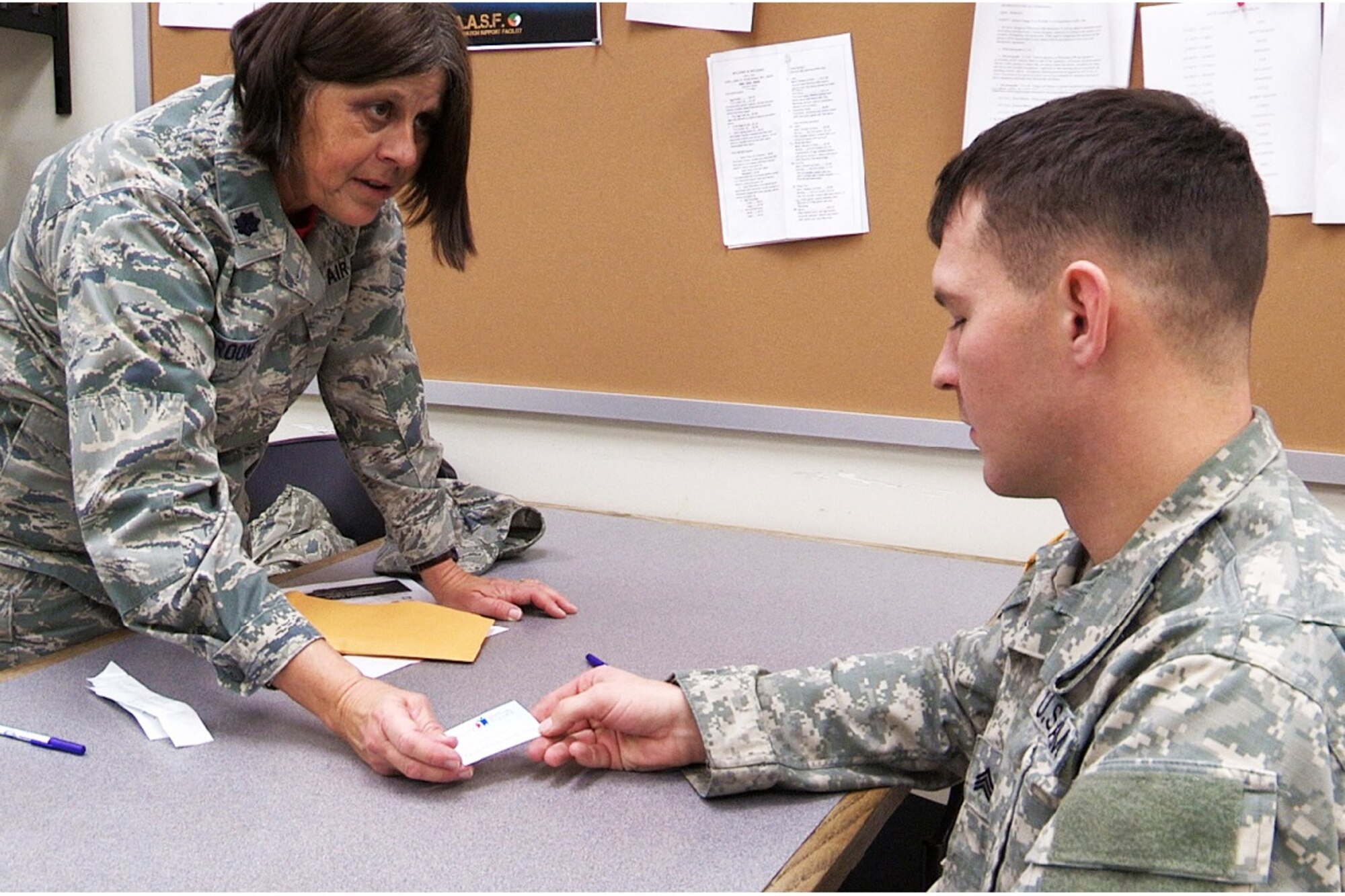 Lt. Col. Janice Kroone, left, 131st Bomb Wing director of staff, accepts a bone marrow donor registration packet from a Soldier from the Missouri Army National Guard’s 1-135th Attack Reconnaissance Battalion.  Kroone recently led a bone marrow registry drive on base that signed up more than 400 registrants.  (U.S. Air National Guard photo by Staff Sgt. Elise Rich)