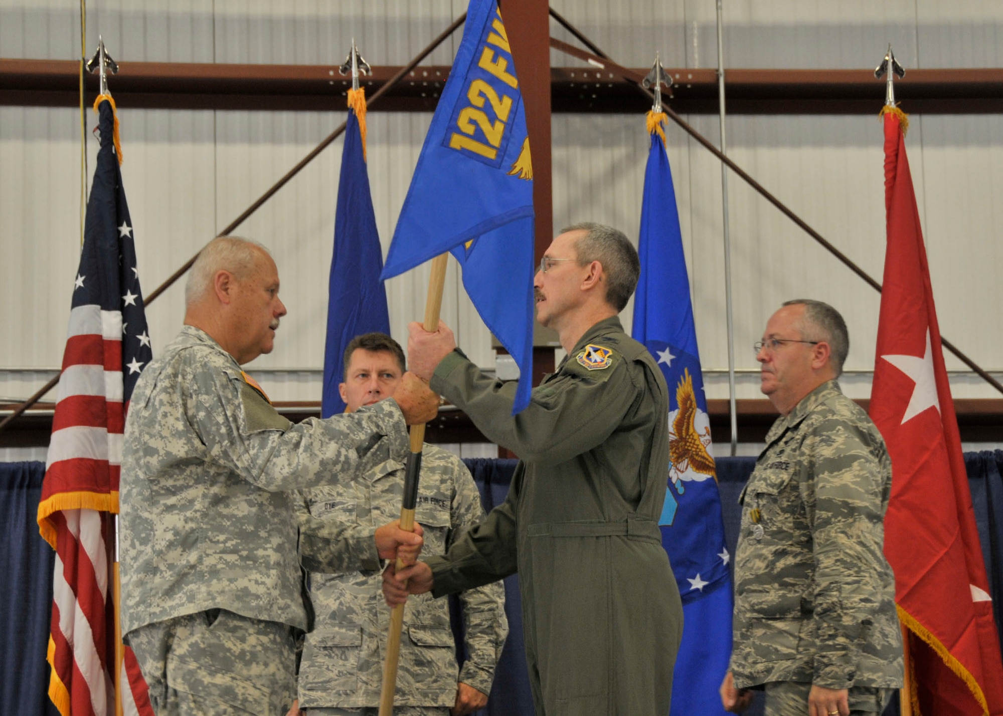 Col. Patrick R. Renwick (center), newly appointed Commander of the 122nd Fighter Wing, Fort Wayne Air National Guard Base, Fort Wayne,  Indiana, hands the wing guidon to Maj. Gen. R. Martin Umbarger (left), the Adjutant General of Indiana, as he assumes command of the wing following the retirement of former wing commander Col. David L. Augustine (right), Sep. 13, 2014. Augustine served as 122FW Commander for over three years. Renwick arrived from the 181st Intelligence Wing, Terra Haute, Indiana, where he served as Vice Commander for three years. (Air National Guard photo by Senior Airman Joseph Boals/Released)