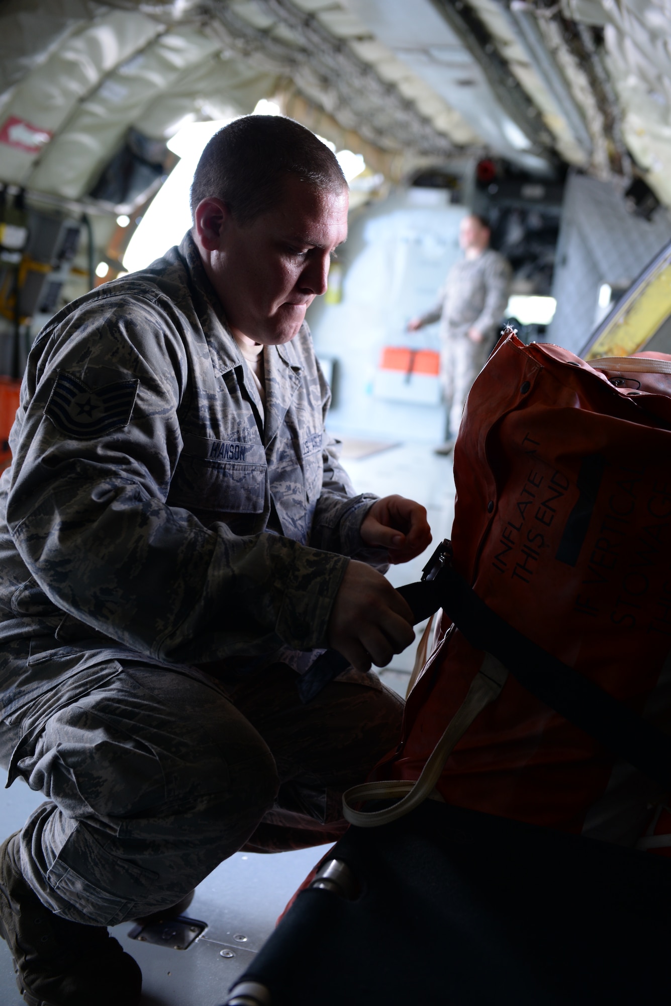U.S. Air Force Tech. Sgt. Adam Hanson inspects and secures an emergency raft to ensure its stability during flight onboard a KC-135 Stratotanker Jan. 23, 2015. Hanson, along with the KC-135, is deployed to the 506th Expeditionary Air Refueling Squadron, Andersen AFB, Guam, as part of the Aircrew Flight Equipment team from the 157th Air Refueling Squadron, Pease ANG Base, N.H. (U.S. Air National Guard photo by Senior Airman Kayla McWalter/RELEASED)